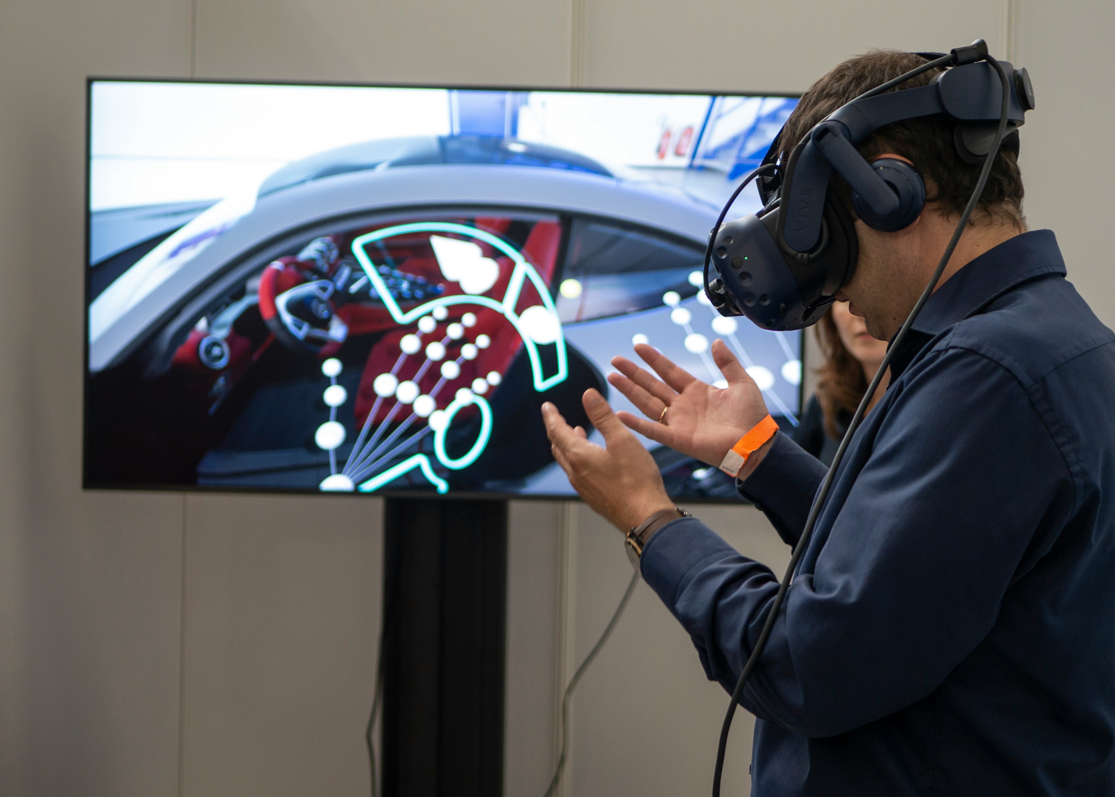 Homme portant une casque de réalité virtuelle devant un écran.