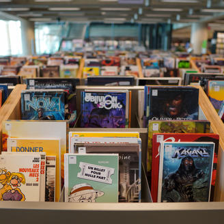 Rangée de bacs contenant des bandes dessinées dans l'Espace BD de la Grande Bibliothèque