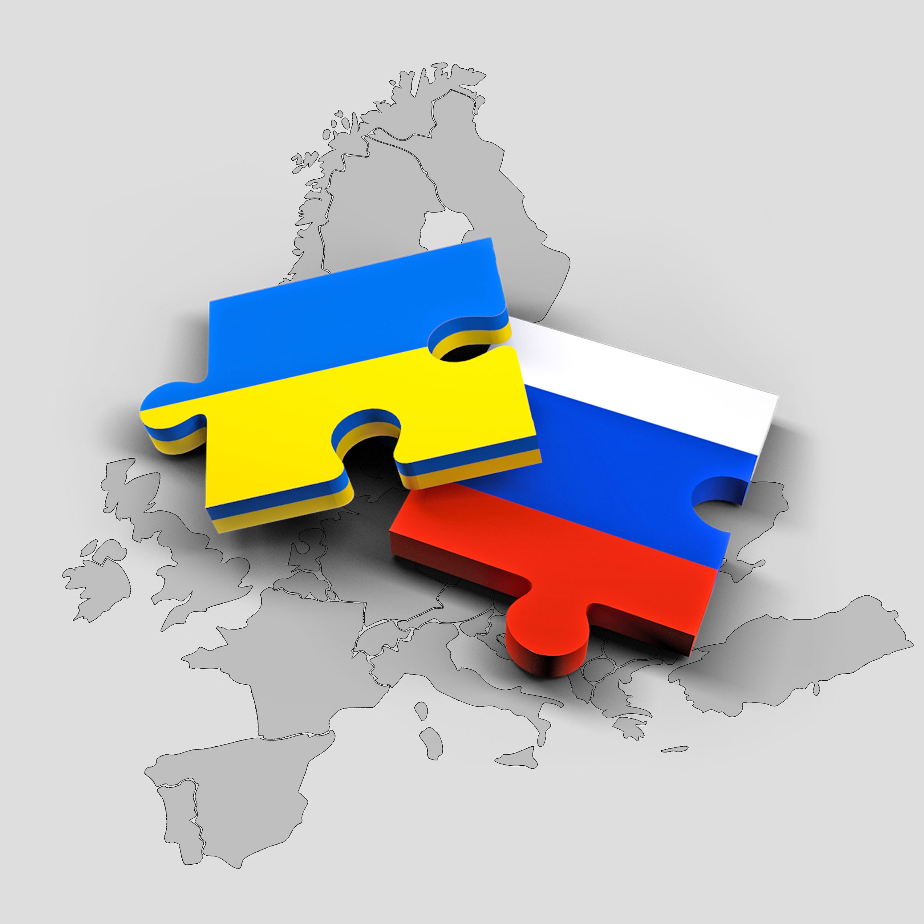 Carte géographique sur laquelle sont déposés des morceaux de casse-têtes aux couleurs des drapeaux de l'Ukraine et de la Russie.