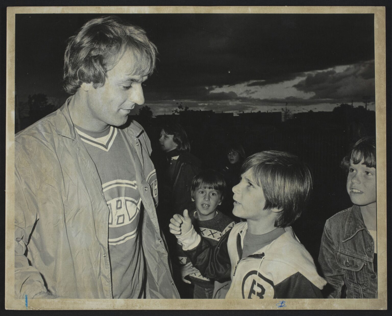 Le 18 août 1977, Guy Lafleur discute avec un jeune garçon portant un chandail des Bruins de Boston après une partie de baseball à Laval.