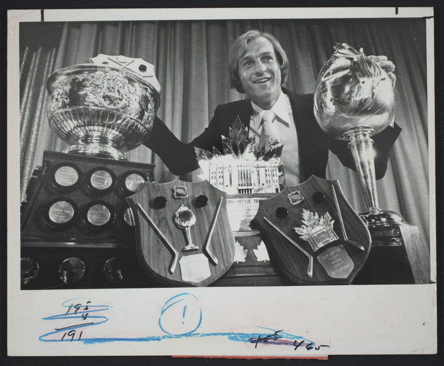 Le 7 juin 1977, Guy Lafleur pose fièrement aux côtés des trophées Conn Smythe, Lester B. Pearson, Art Ross et Hart remportés durant la saison exceptionnelle 1976-1977.