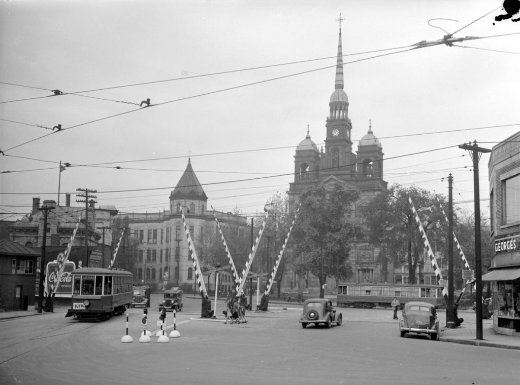 La place Saint-Henri avec ses tramways, ses barrières de traverse de chemin de fer et l’église de Saint-Henri, démolie en 1969, 29 août 1945.