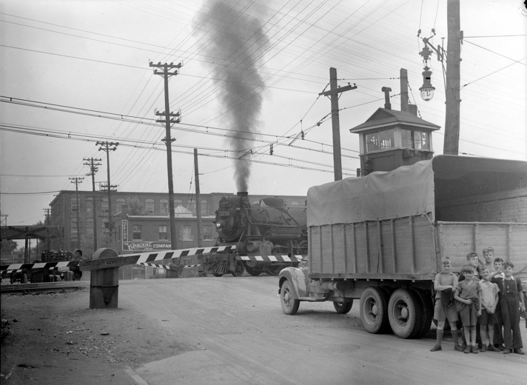 L’arrivée du train bloque le passage d’un camion au croisement des rues Saint-Augustin et Saint-Ambroise à Montréal, 29 août 1945.