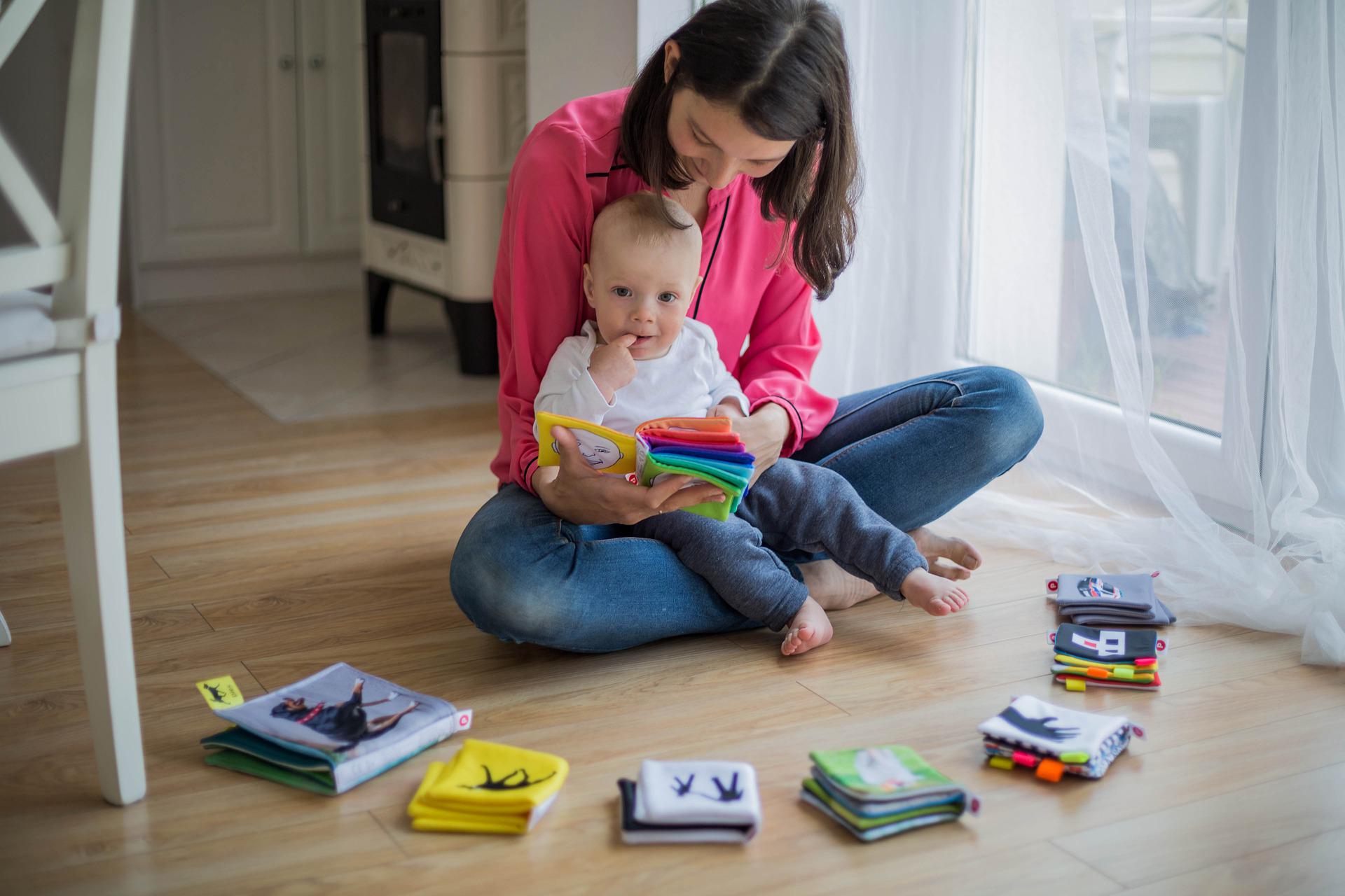 Une femme montre un livre à un bébé.