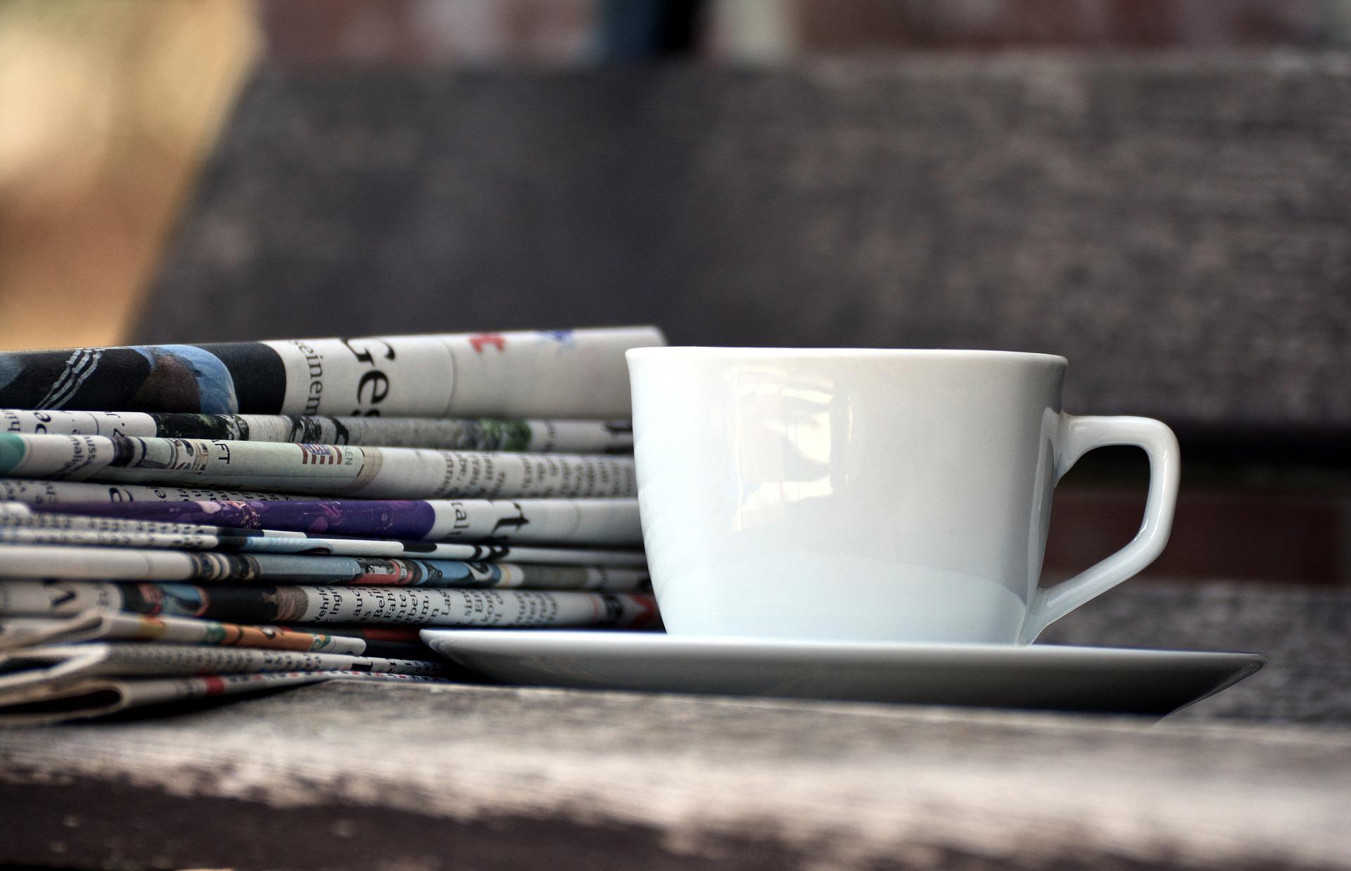 Tasse et pile de journaux.