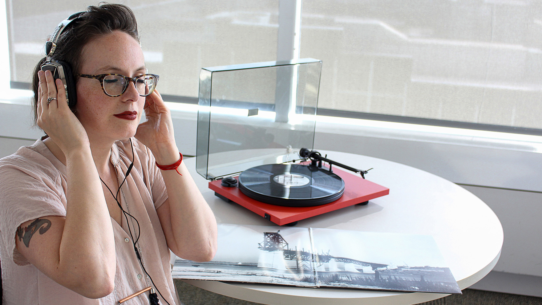 Une femme écoute un disque vinyle avec un casque d'écoute.