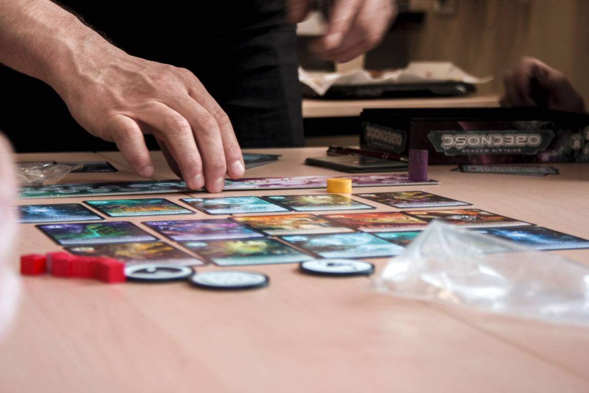 Main qui manipule les pièces d'un jeu de société.