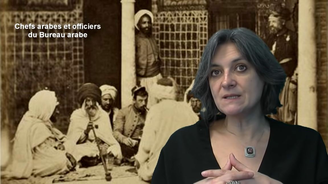 Femme devant une photo ancienne montrant des chefs et officiers arabes.