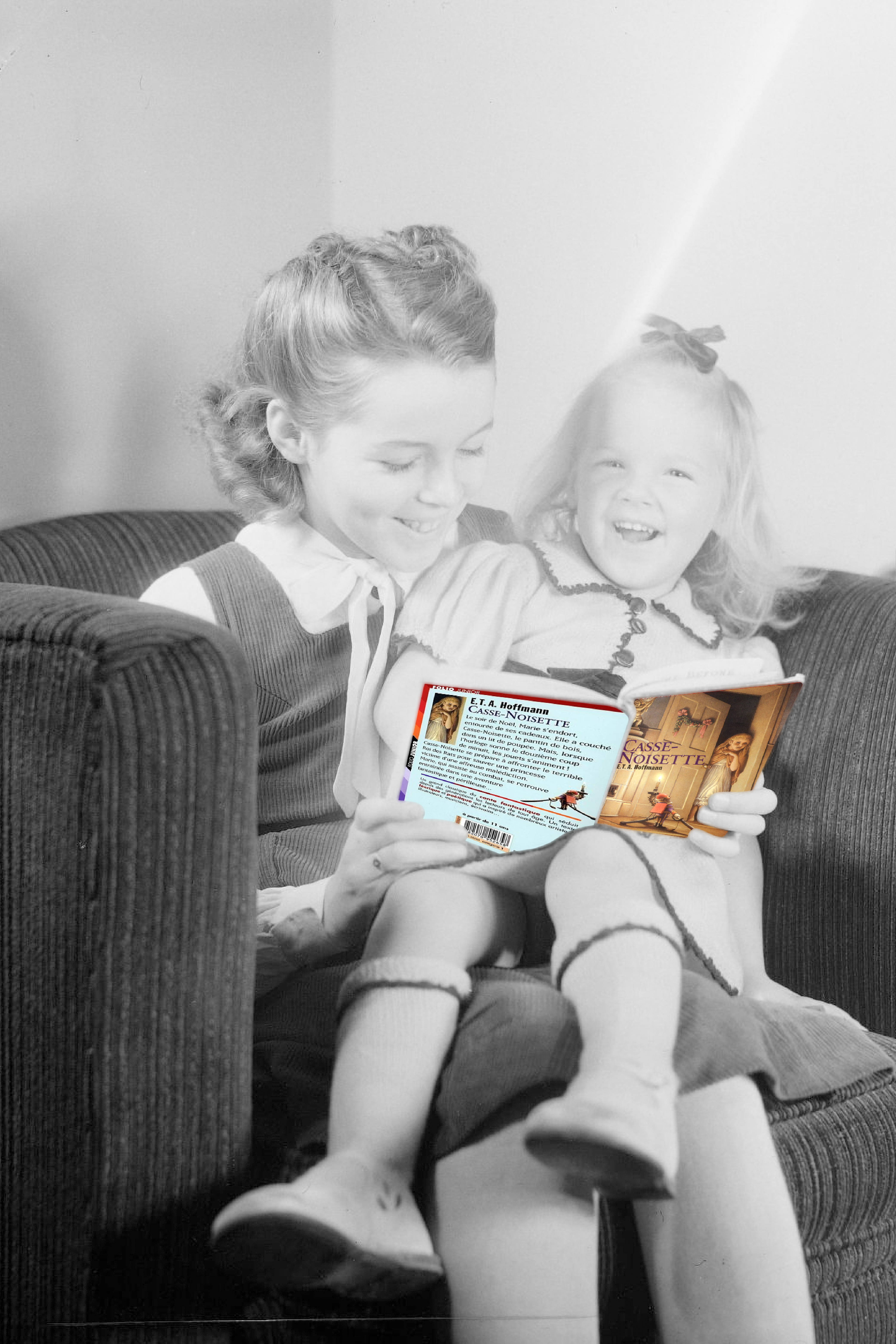 Une enfant fait la lecture à sa petite soeur.