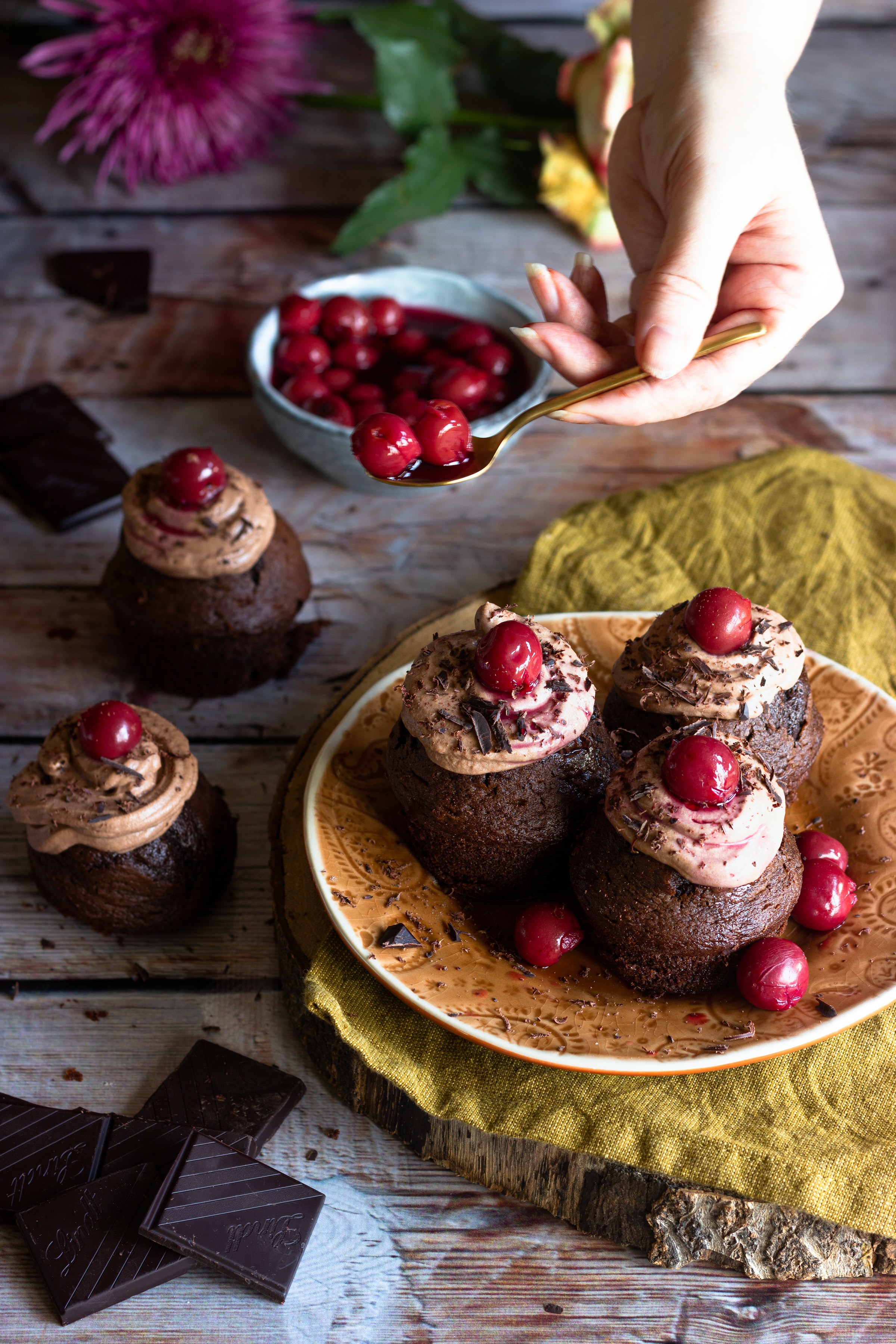 Main d'une femme qui ajoute la garniture à un dessert au chocolat.