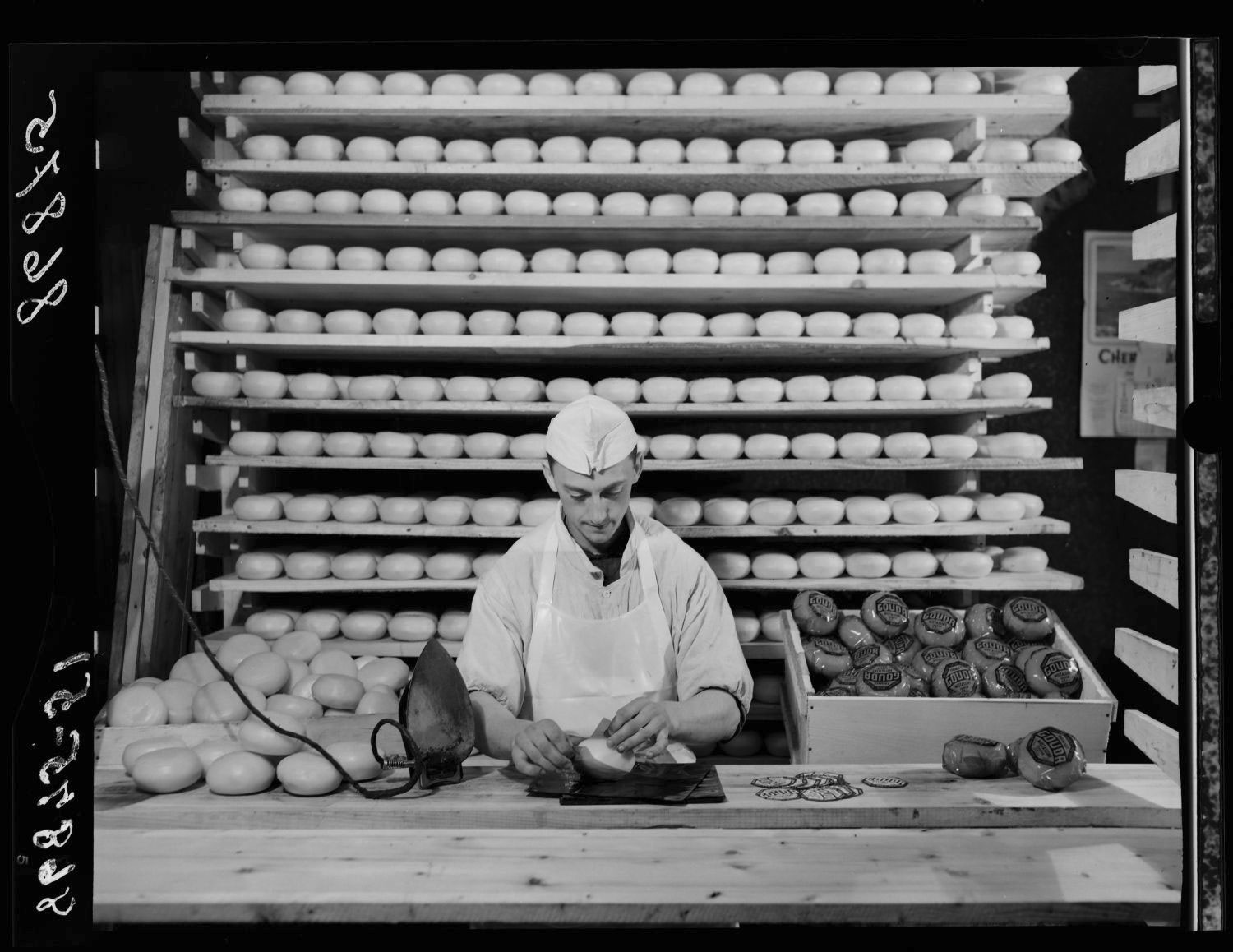 Homme emballant un fromage.