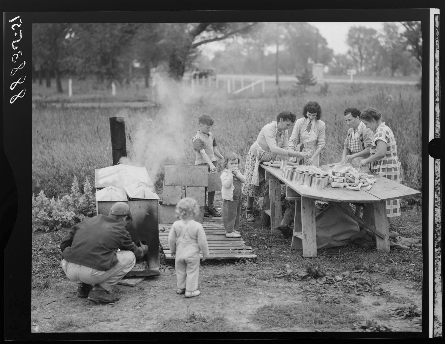 Groupe de personnes s'adonnant à la mise en conserve de maïs.