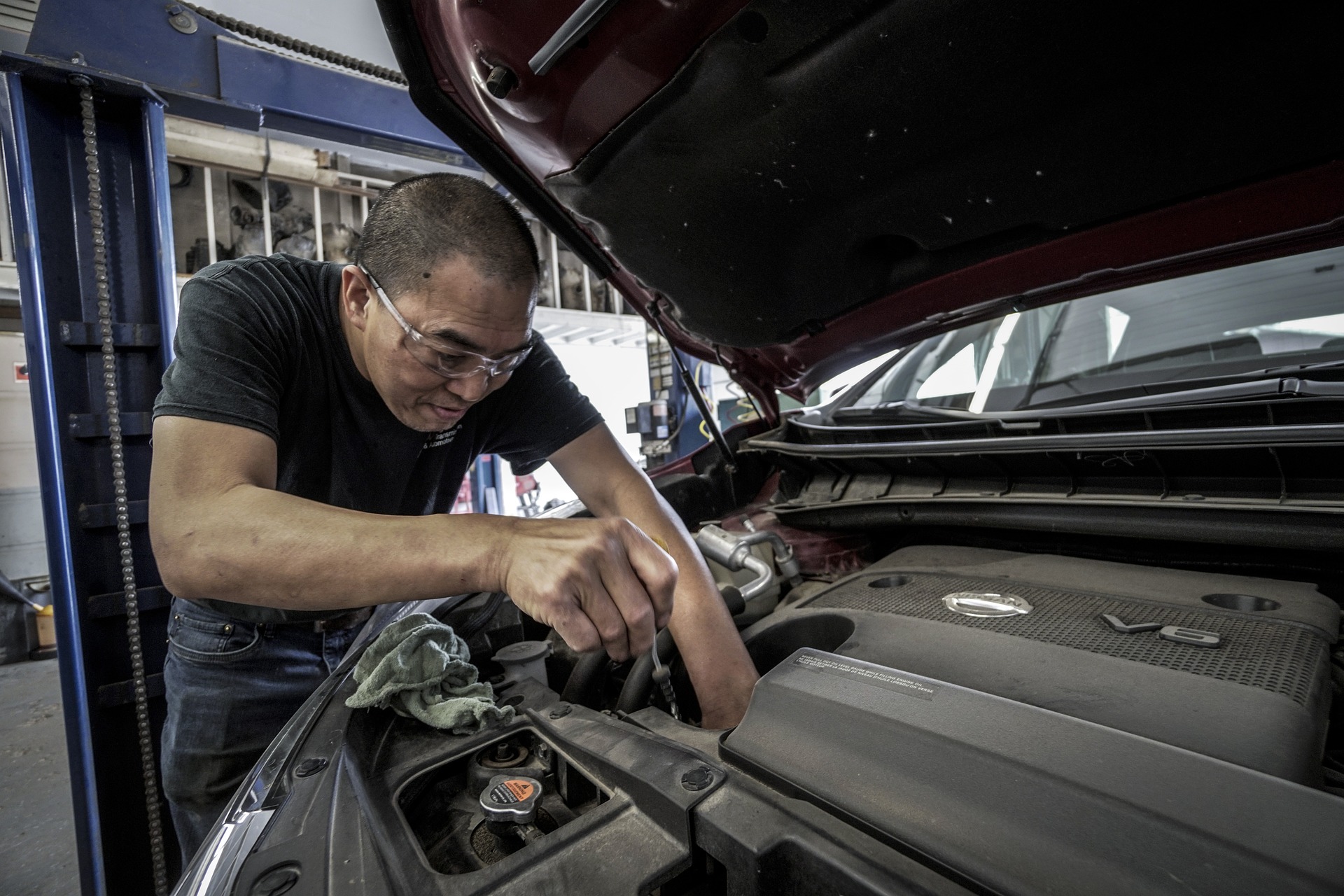 Un homme répare le moteur d'une voiture.