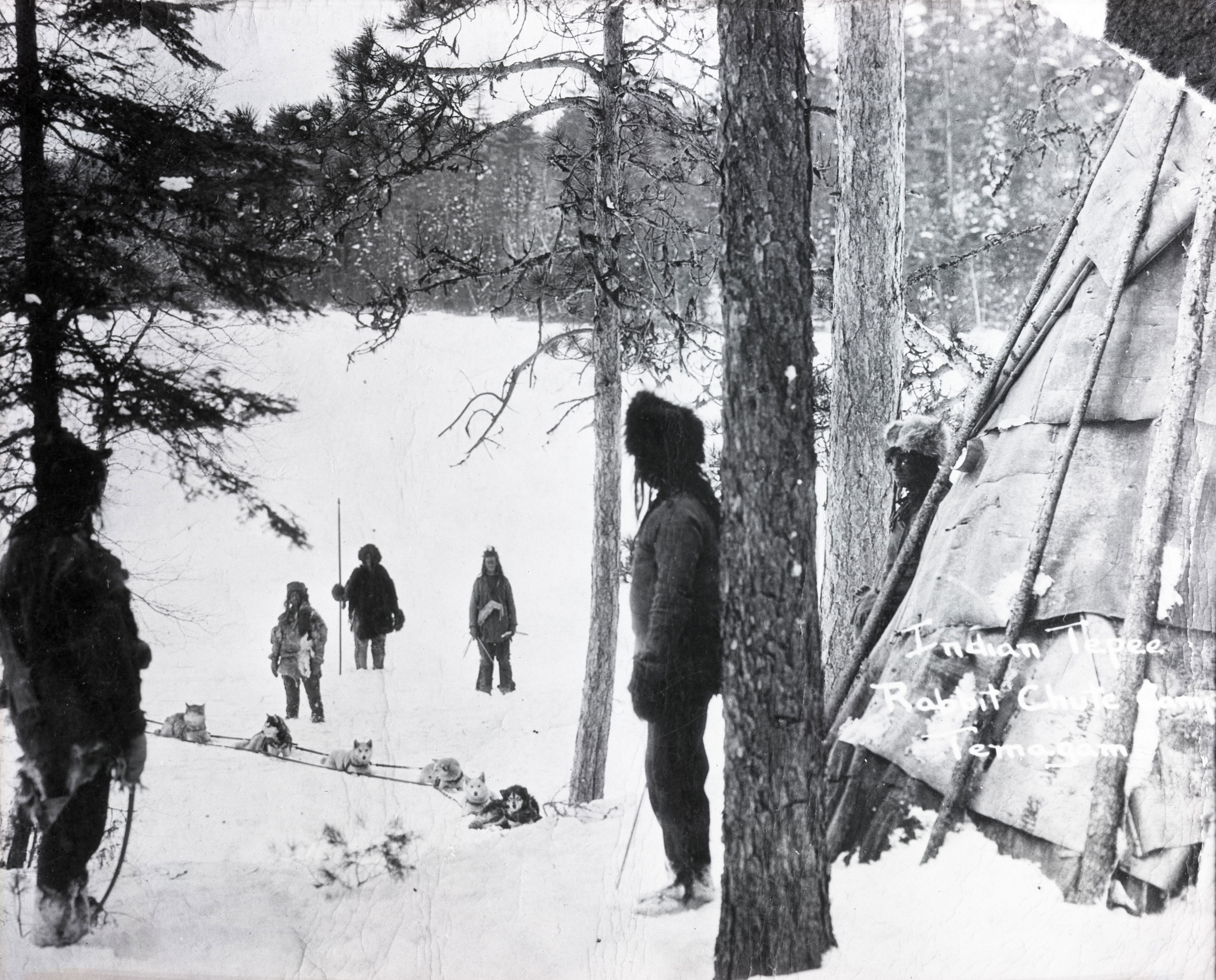 Scène de chasse avec six personnes et des chiens dans un décor hivernal.