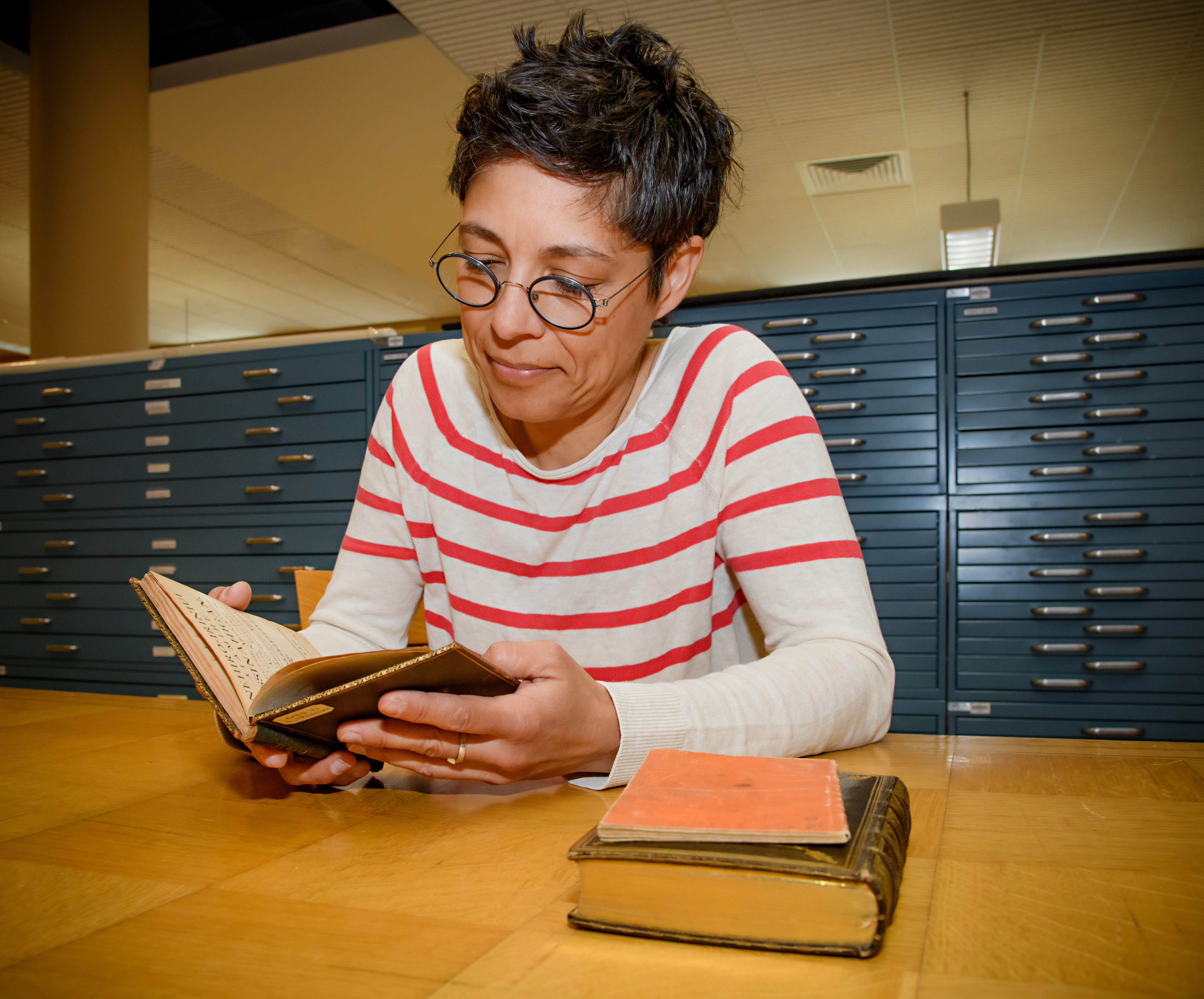 Une bibliothécaire consulte un livre ancien en langue autochtone