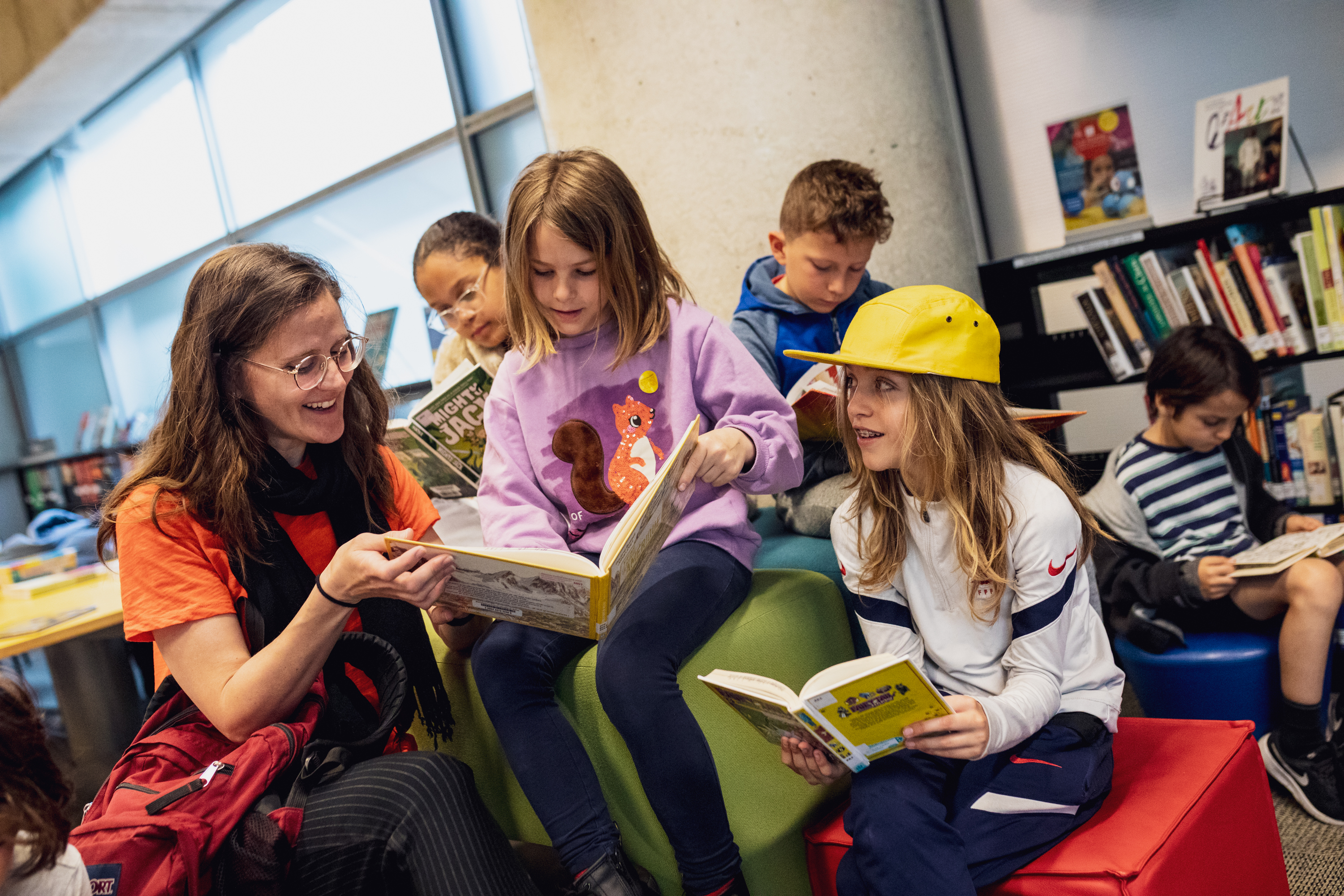 Jeune femme et enfants en train de lire.
