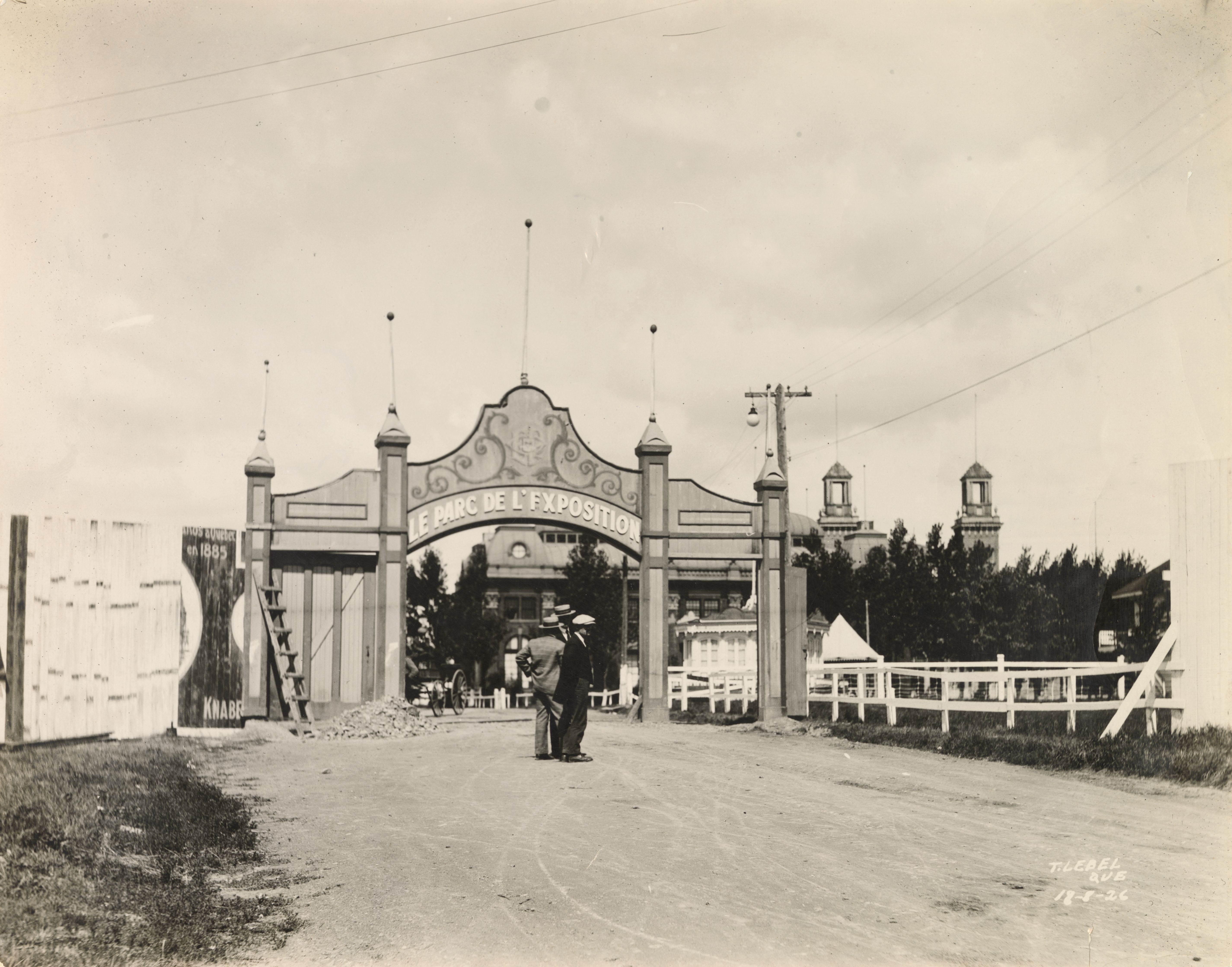 Deux hommes se tiennent devant l'entrée principal du parc de l'exposition de 1926
