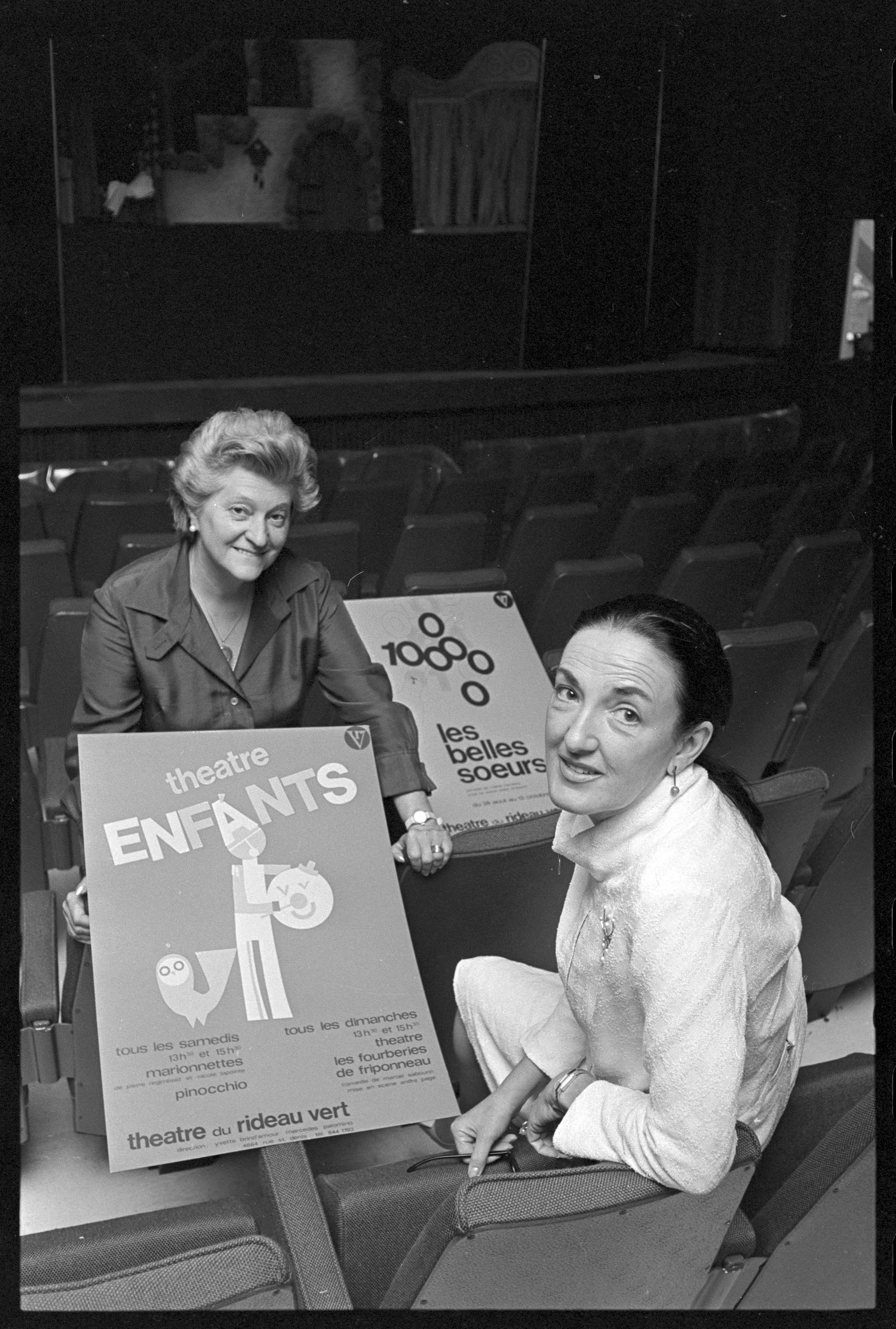 Mercedes Palomino et Yvette Brind’Amour montrant des affiches dans la salle de spectacle du Rideau vert.