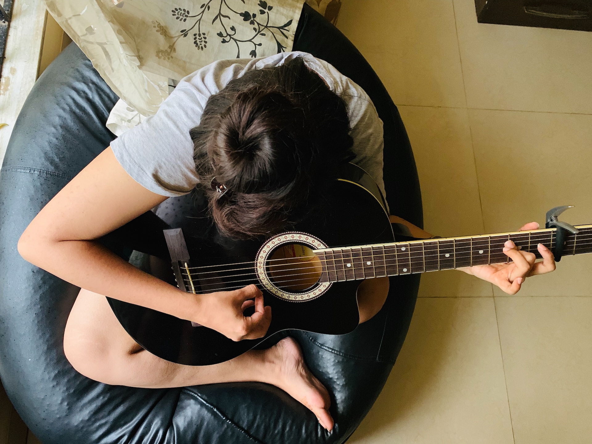Jeune femme jouant de la guitare acoustique.
