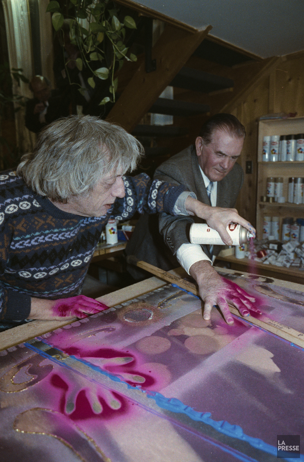 Le peintre Jean Paul Riopelle applique une peinture rouge sur la main de Maurice Richard