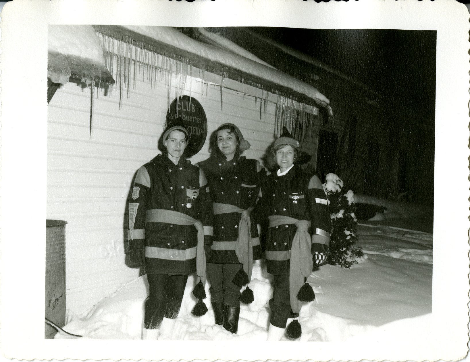 Trois raquetteuses dehors l'hiver devant le chalet du club l'Audacieux.