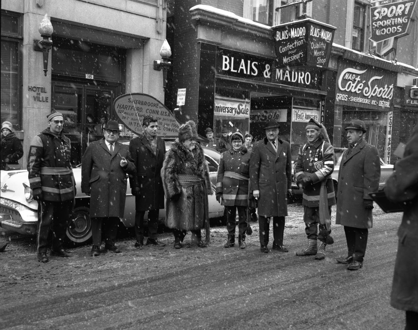 Charles Delorme, entouré de confrères du club l’Audacieux dans la rue devant une voiture.