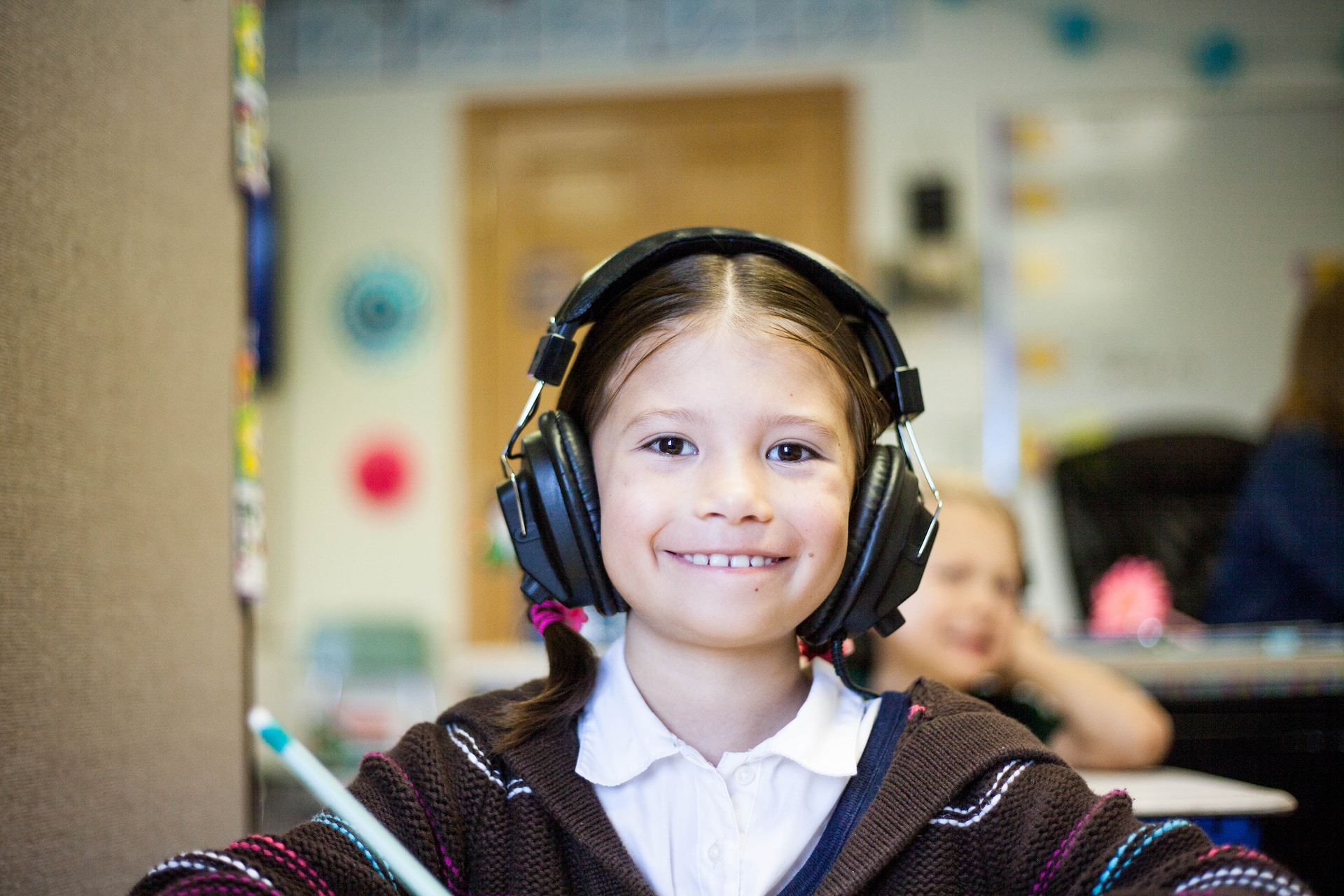 Fillette en classe avec un casque d'écoute.