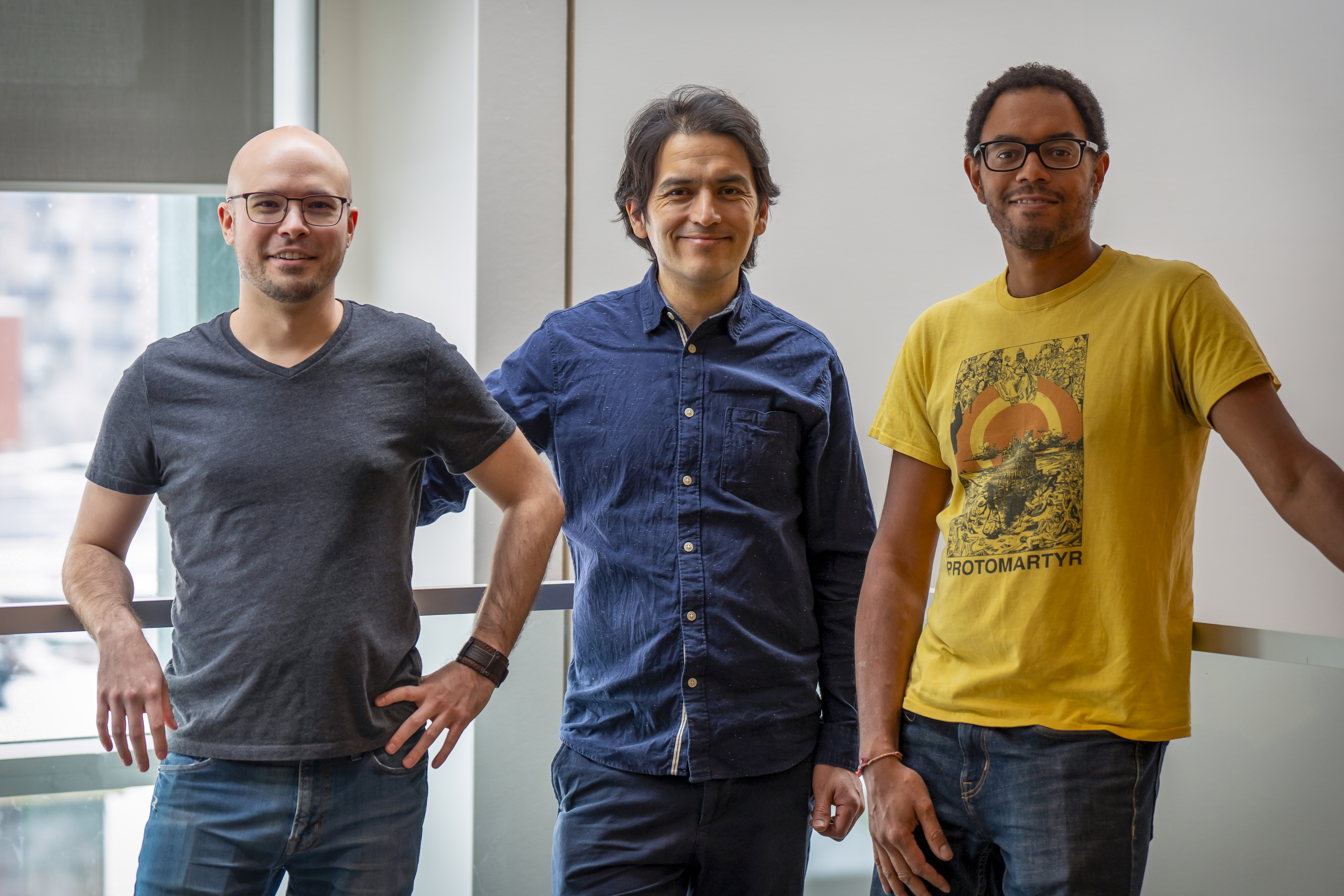 Trois hommes souriants.