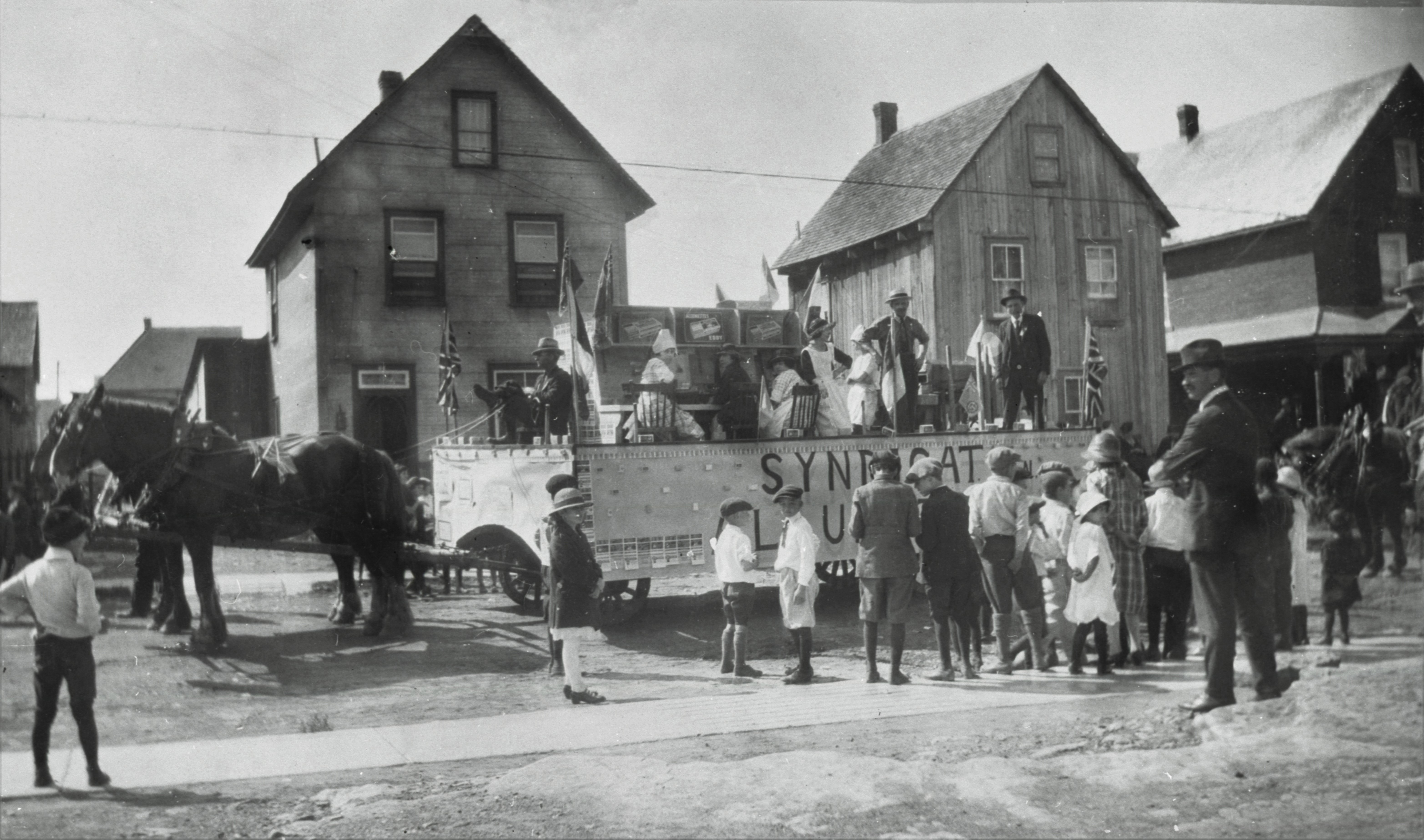 Des hommes, femmes et enfants près d'un char allégorique pour le défilé de la fête du Travail.