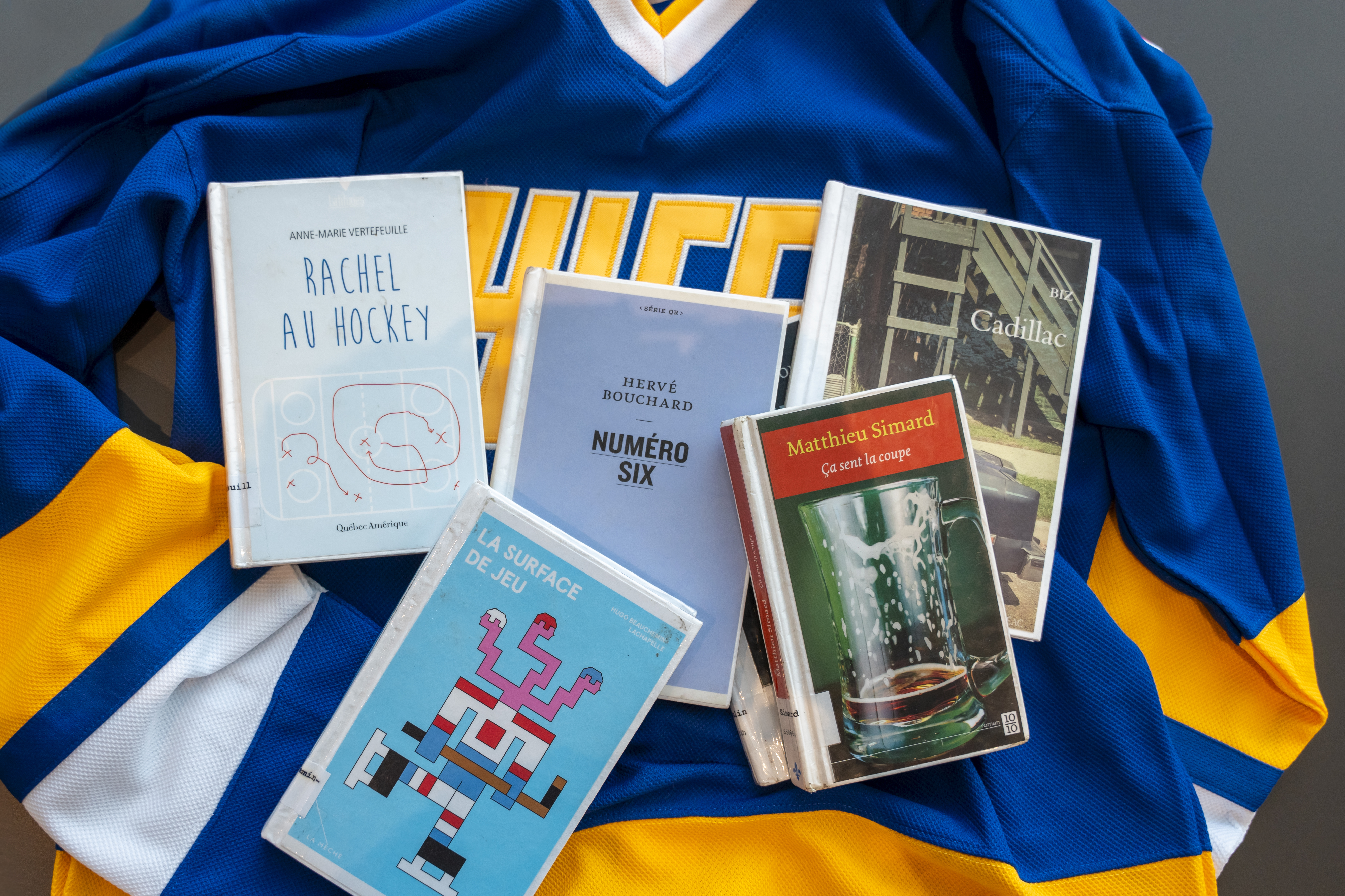 Cinq romans dont l'action tourne autour du hockey sont posés sur un chandail de hockey.