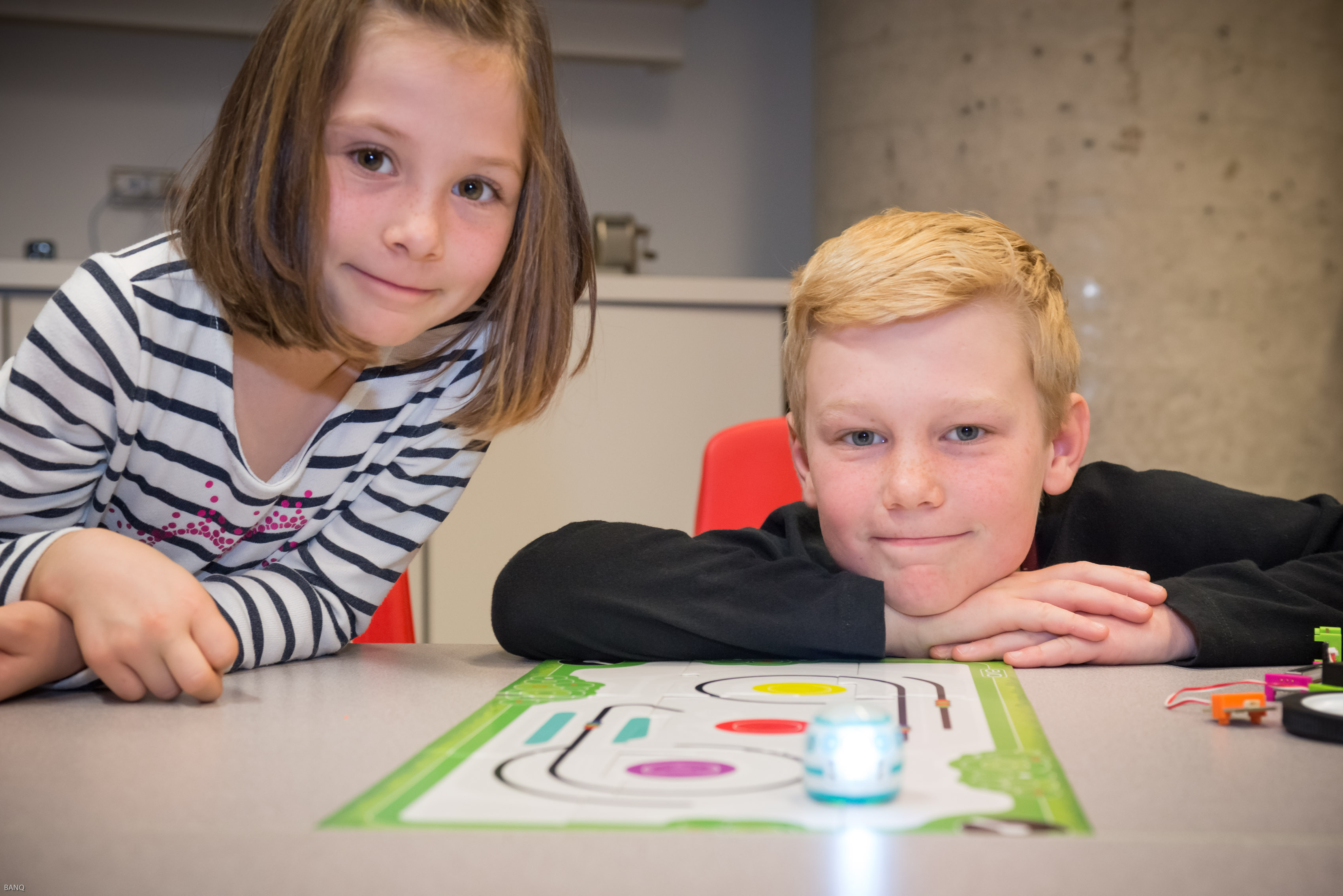 Deux enfants devant un robot Ozobot.