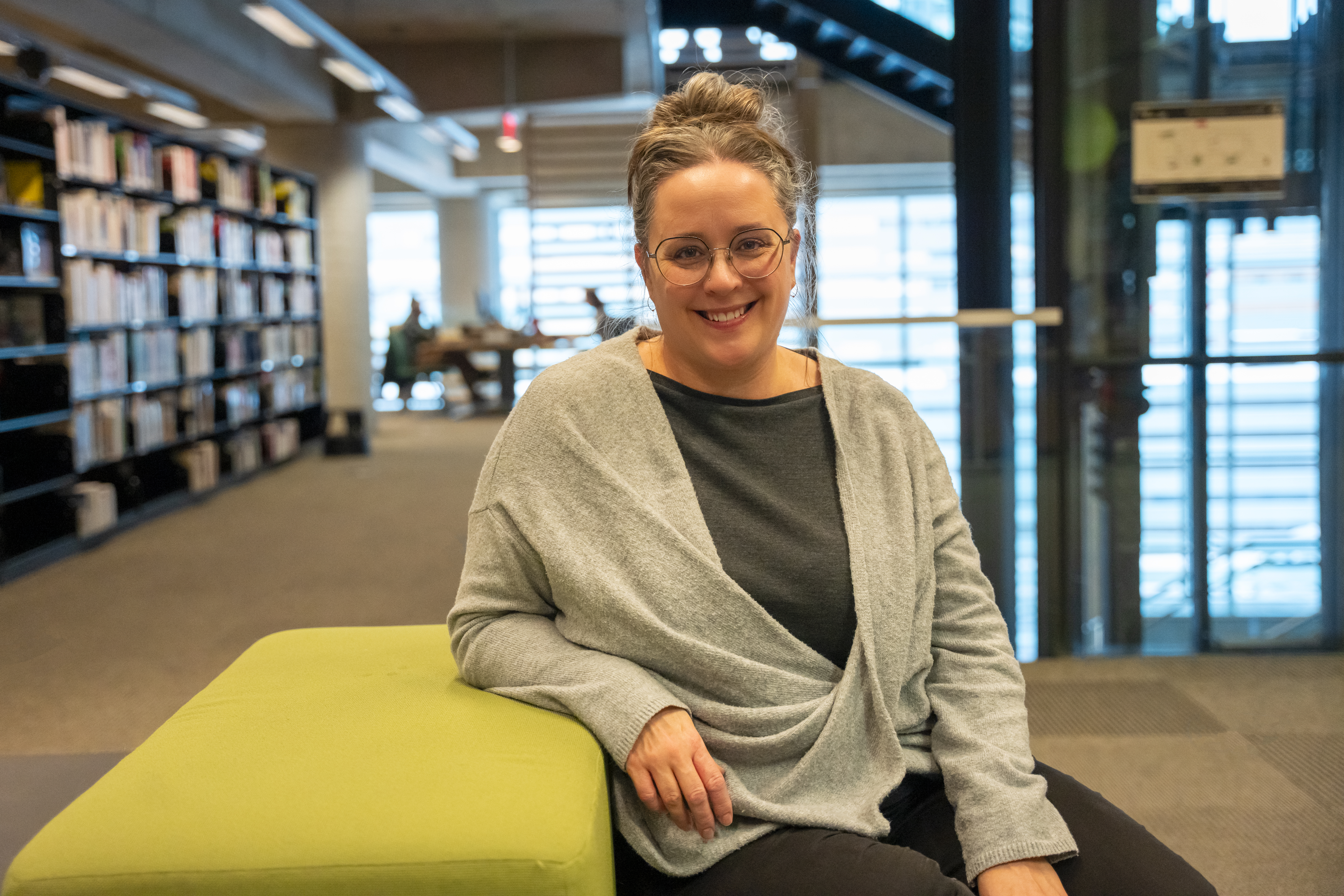 Femme souriante assise à la Grande Bibliothèque.