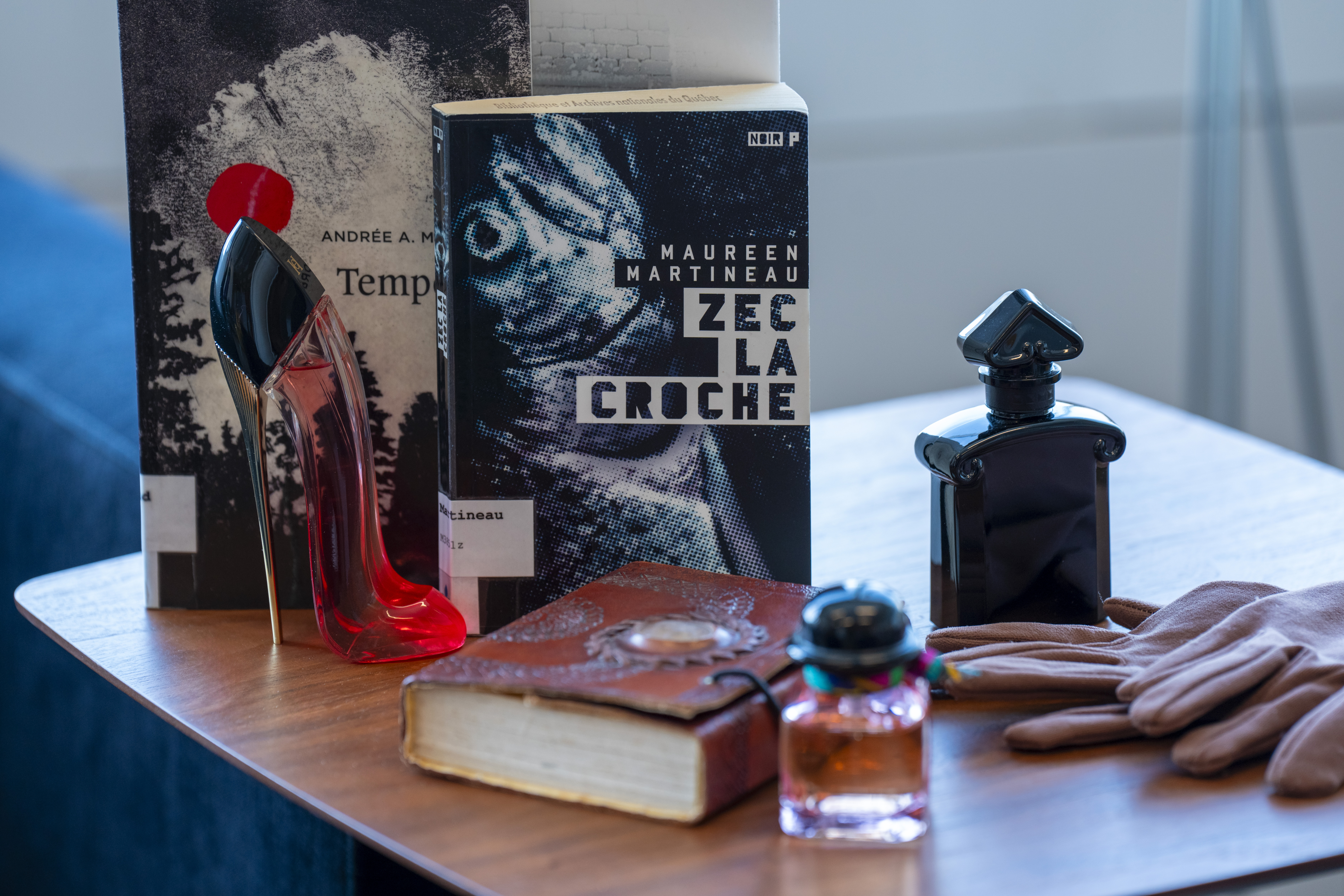 Des flacons de parfum, une paire de gants et les livres Tempêtes et ZEC La Croche