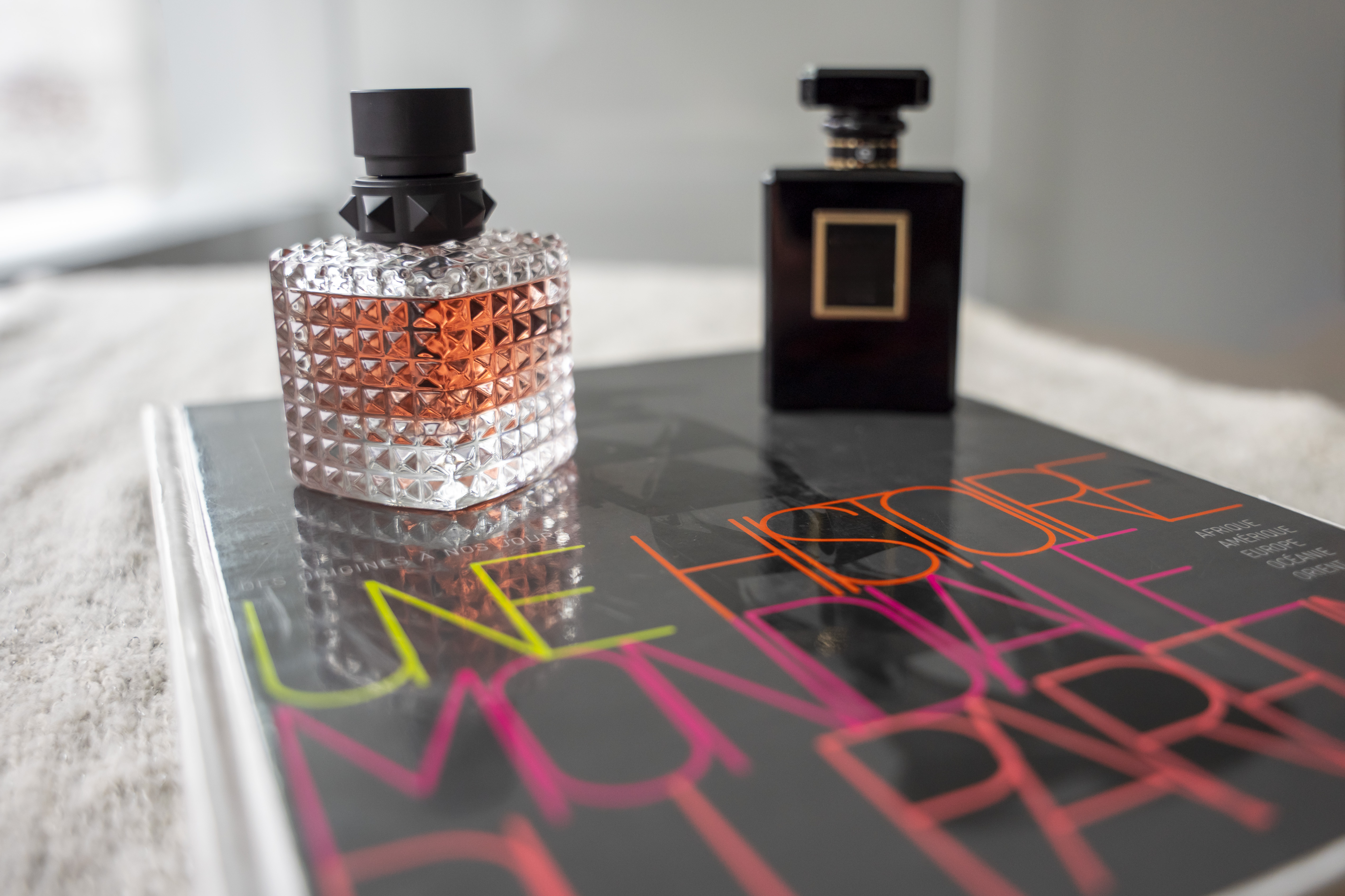 Deux flacons de parfum posés sur le livre Une histoire mondiale du parfum.