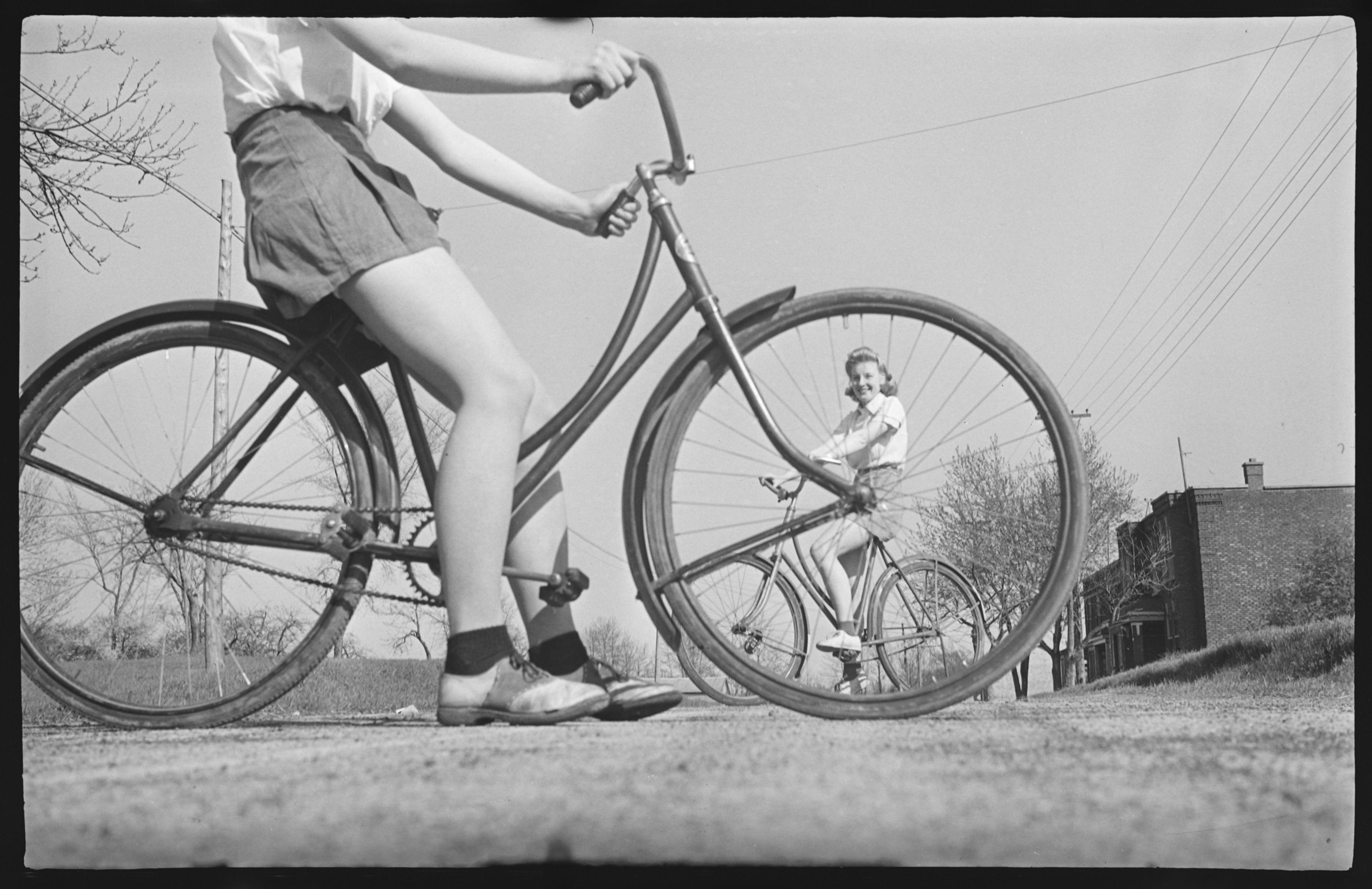 Photo ancienne présentant deux jeunes femmes à vélo.