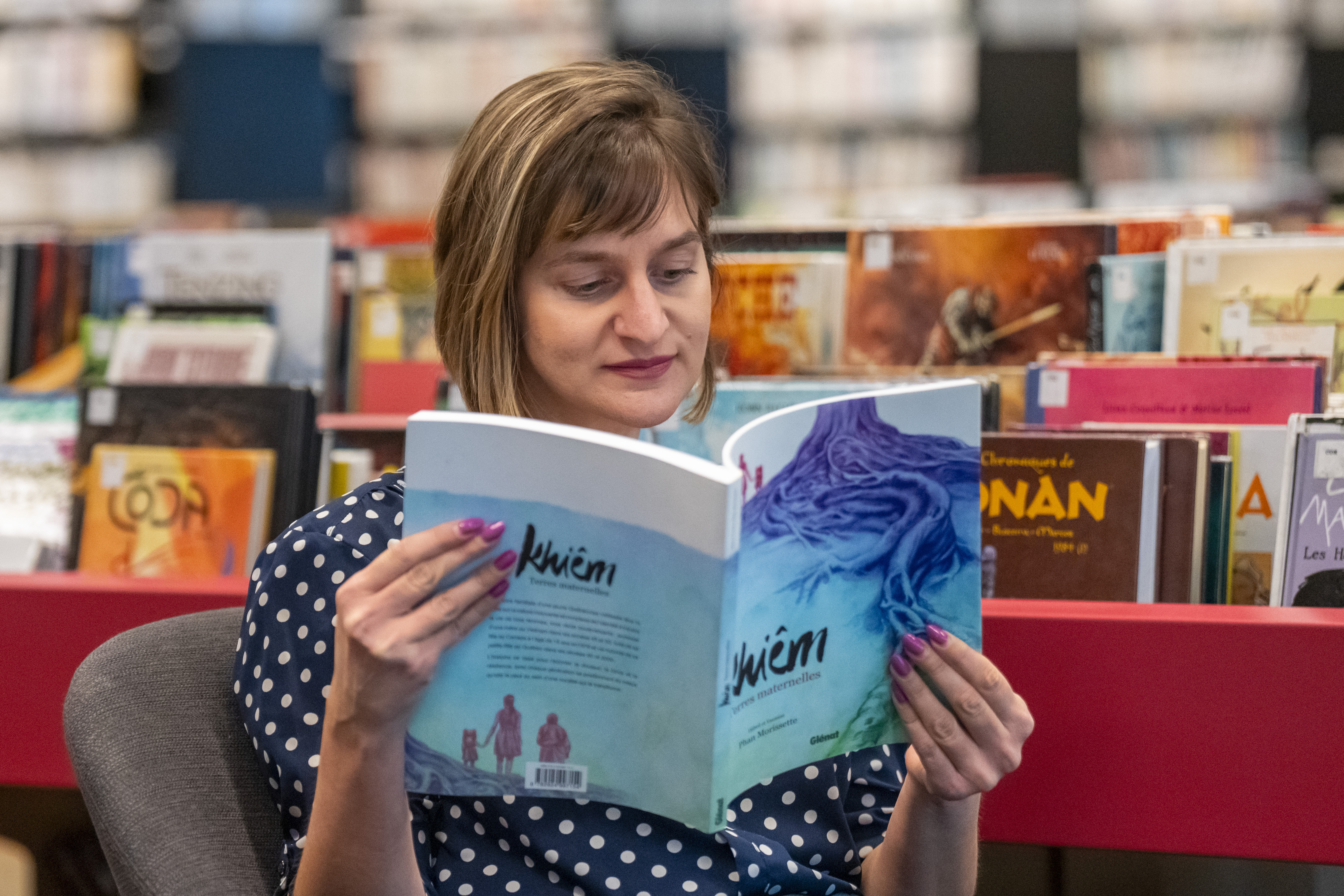 Femme lisant la bande dessinées « Khiêm », de Djibril Chu'o'ng.