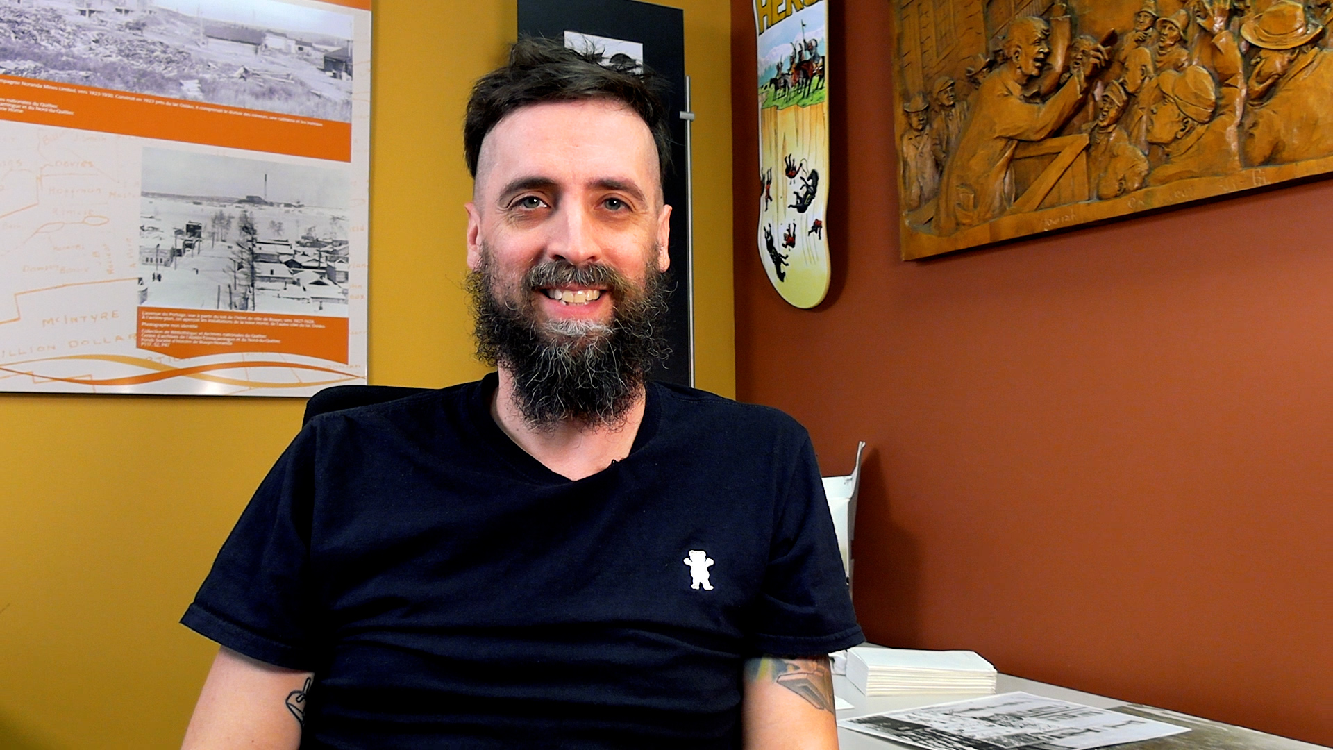 Portrait d'un homme barbu et souriant.