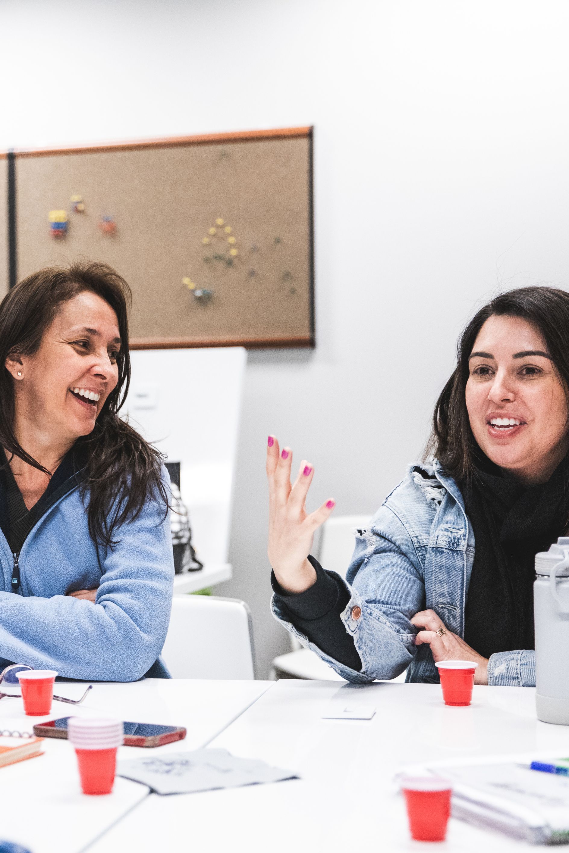 Deux femmes qui parlent et rient ensemble lors d'un atelier de conversation