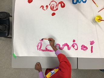 Photographie à vue d'oiseau d'une enfant qui peint
