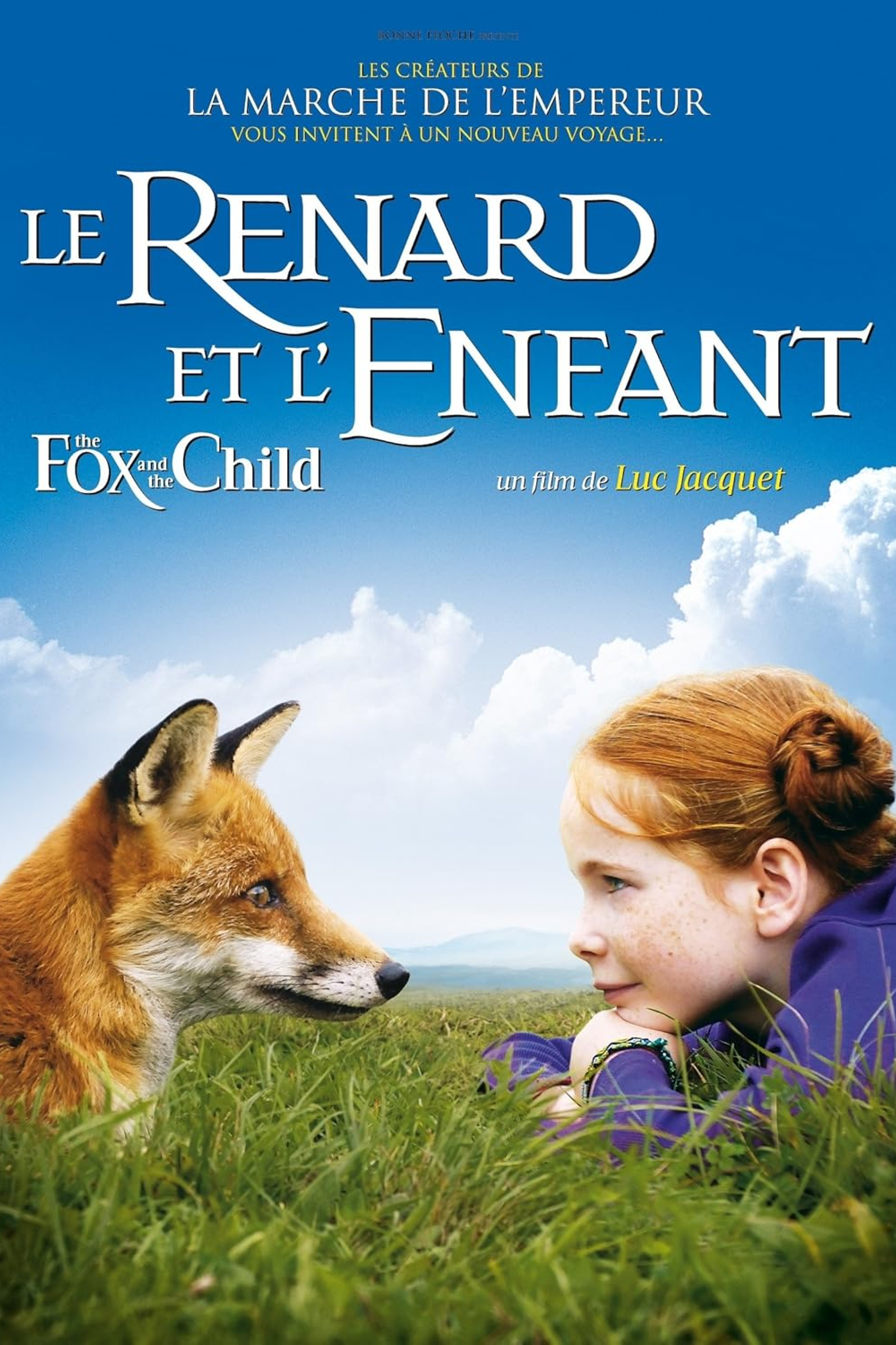 Une jeune fille est couchée dans l'herbe, sur le ventre, face à un renard.