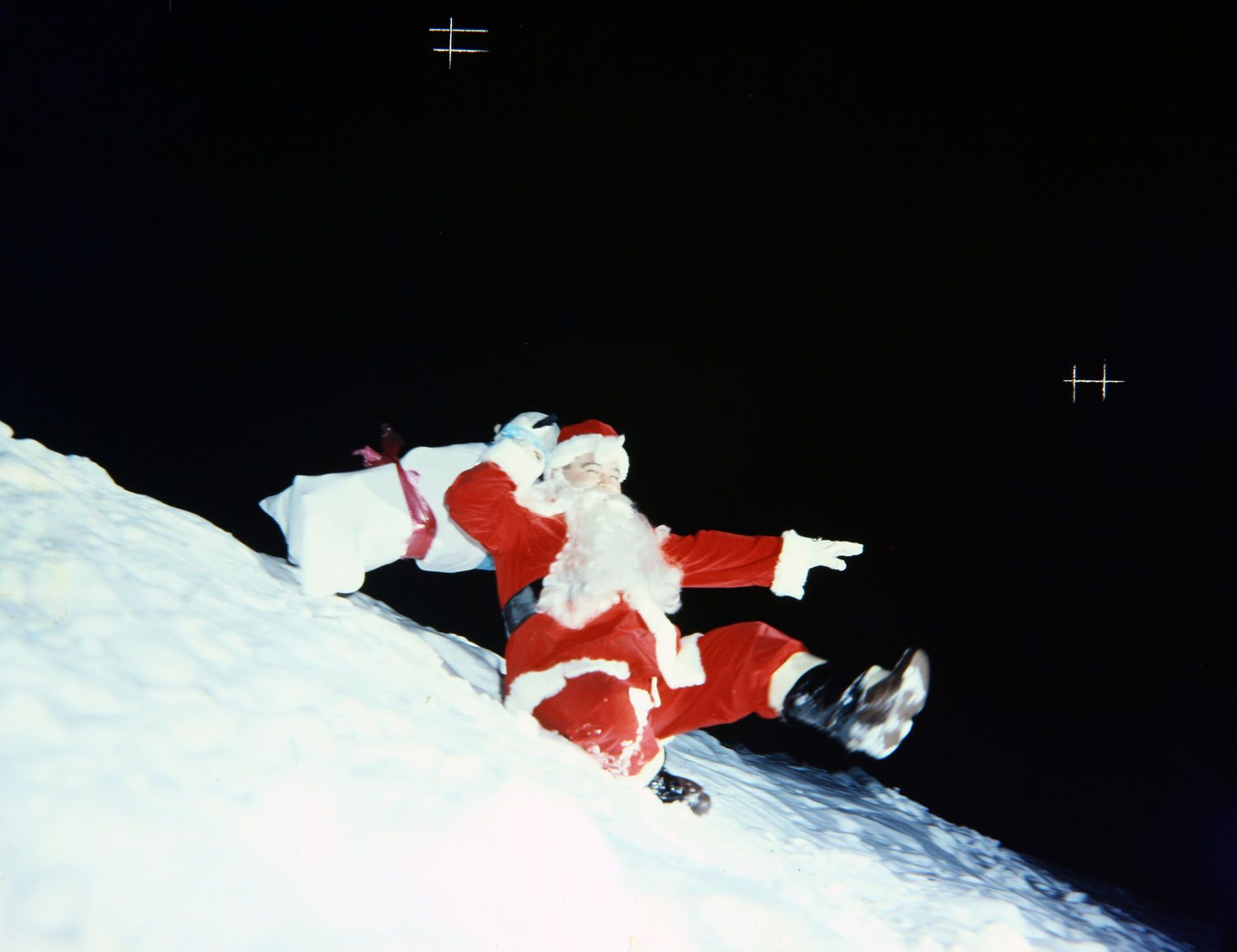 Un père Noël glisse sur la neige.