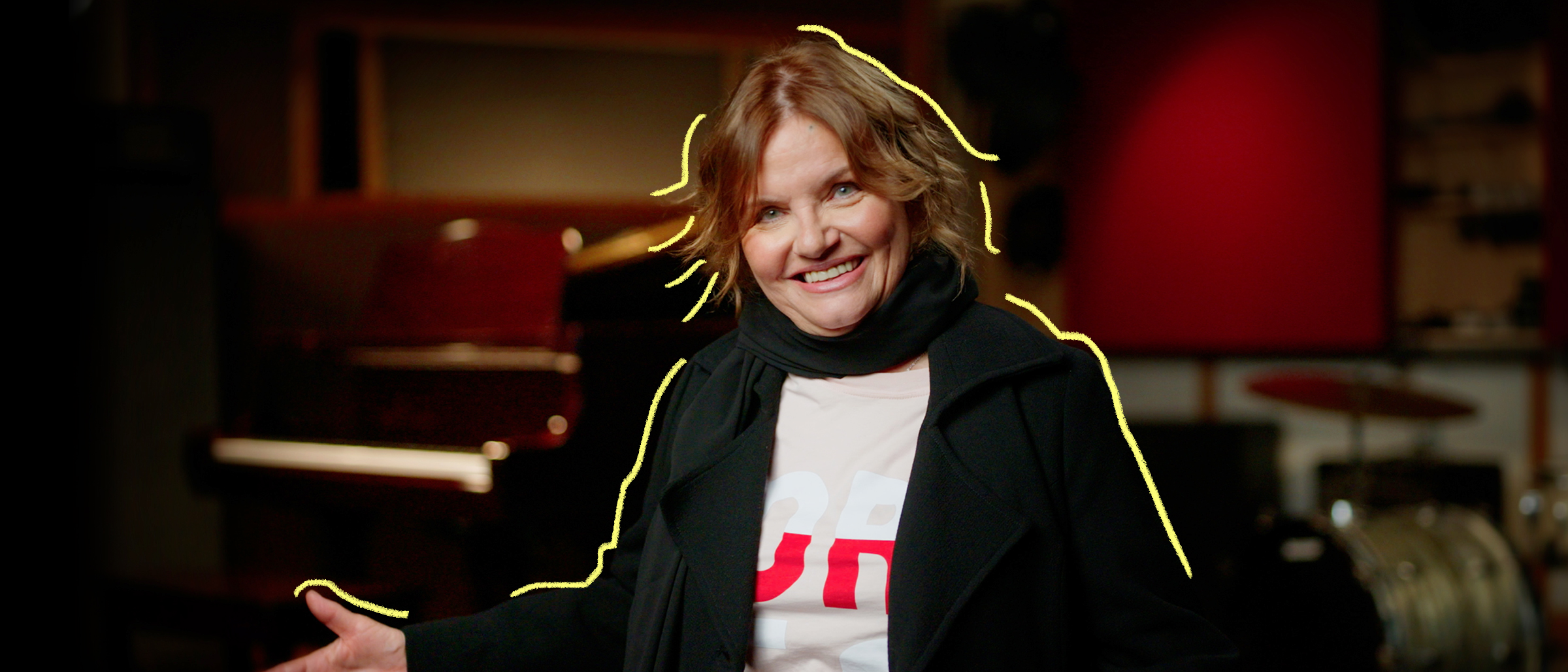 La chanteuse Diane Tell souriante dans un studio de musique