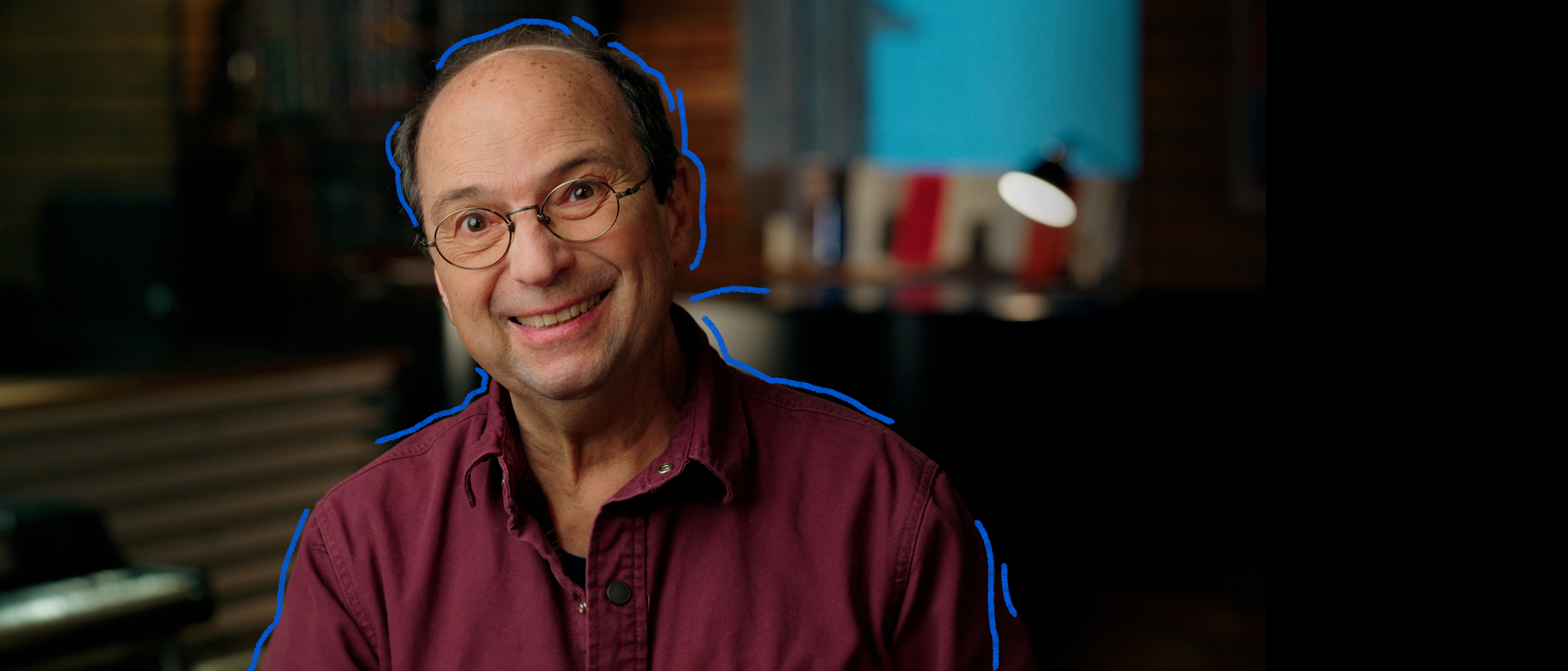 Le chanteur Michel Rivard souriant dans un studio de musique