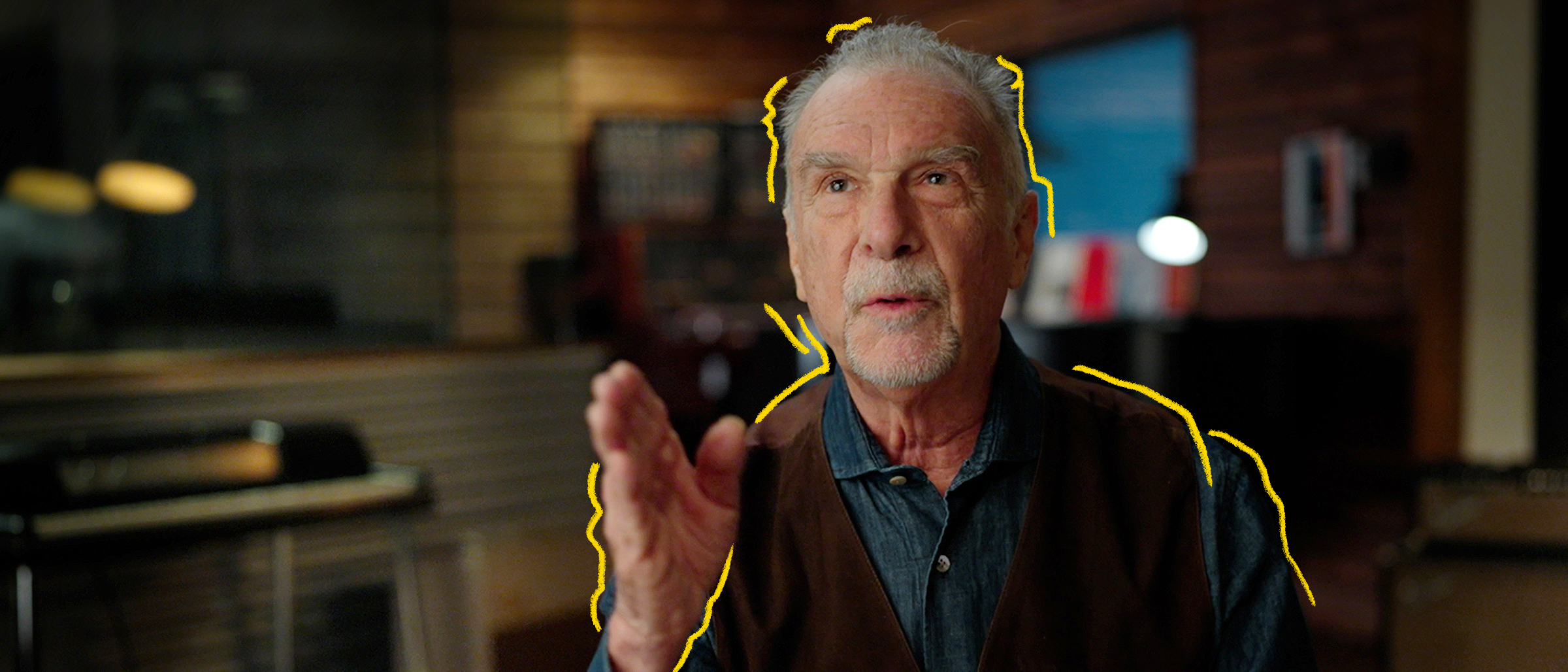 Le chanteur Zachary Richard dans un studio de musique montrant une direction de la main