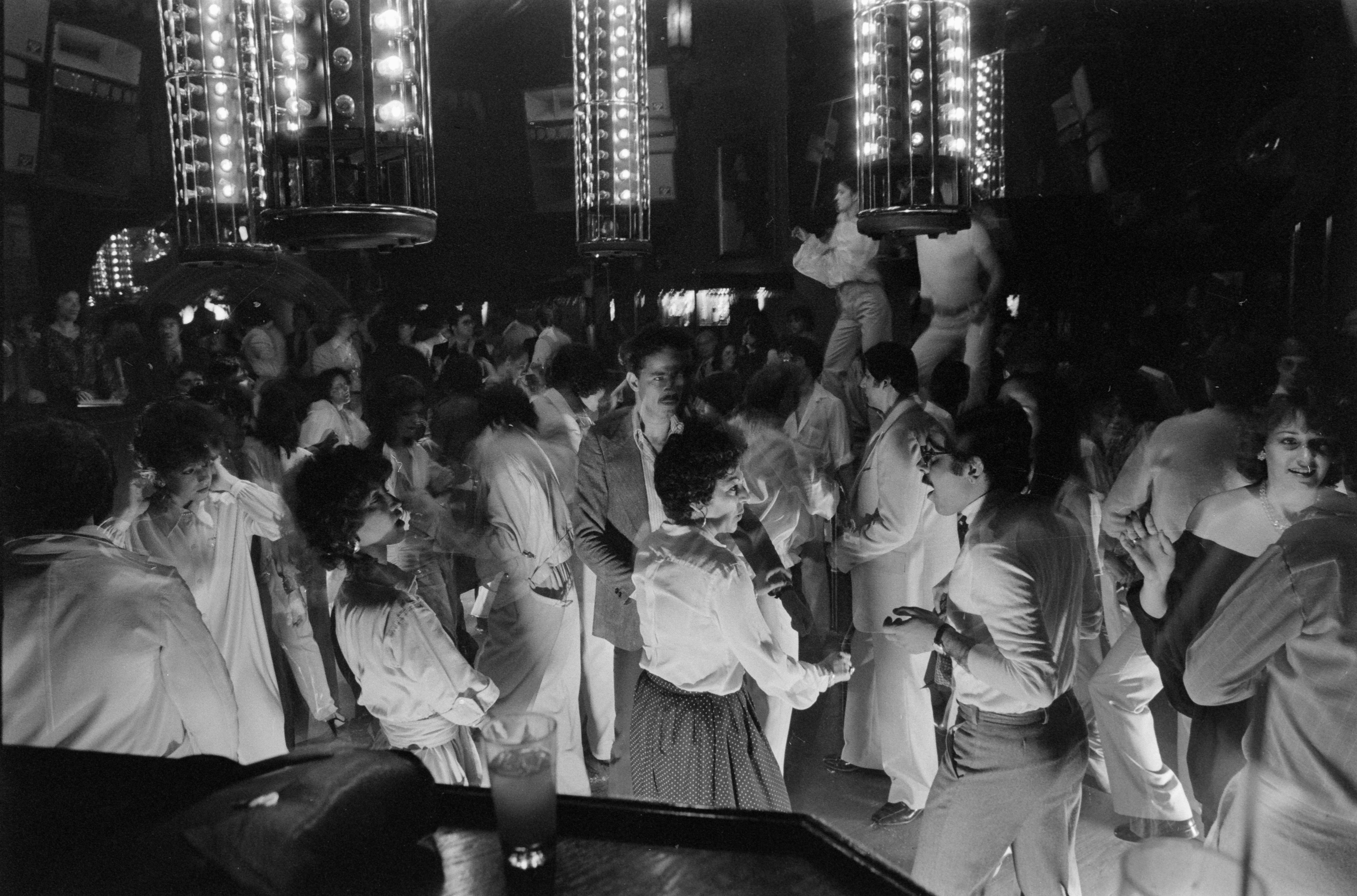 Hommes et femmes sur la piste de danse d'une discothèque.