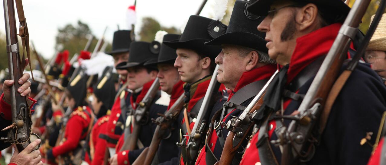 Hommes habillés en soldats du 18e siècle.