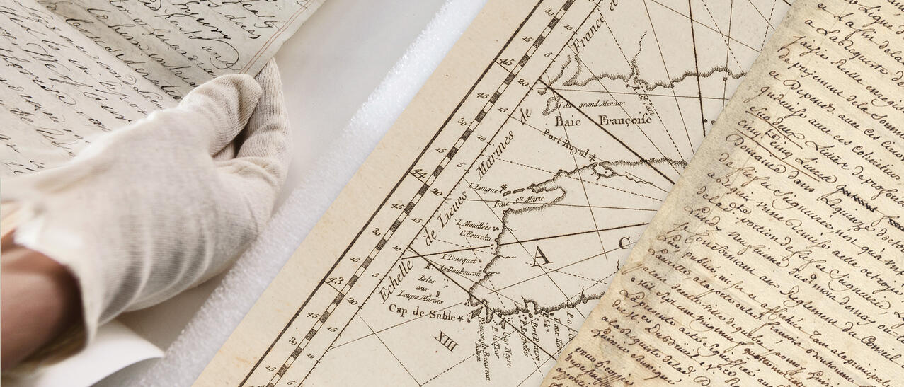 Vieux documents consultés par un employés des Archives nationales