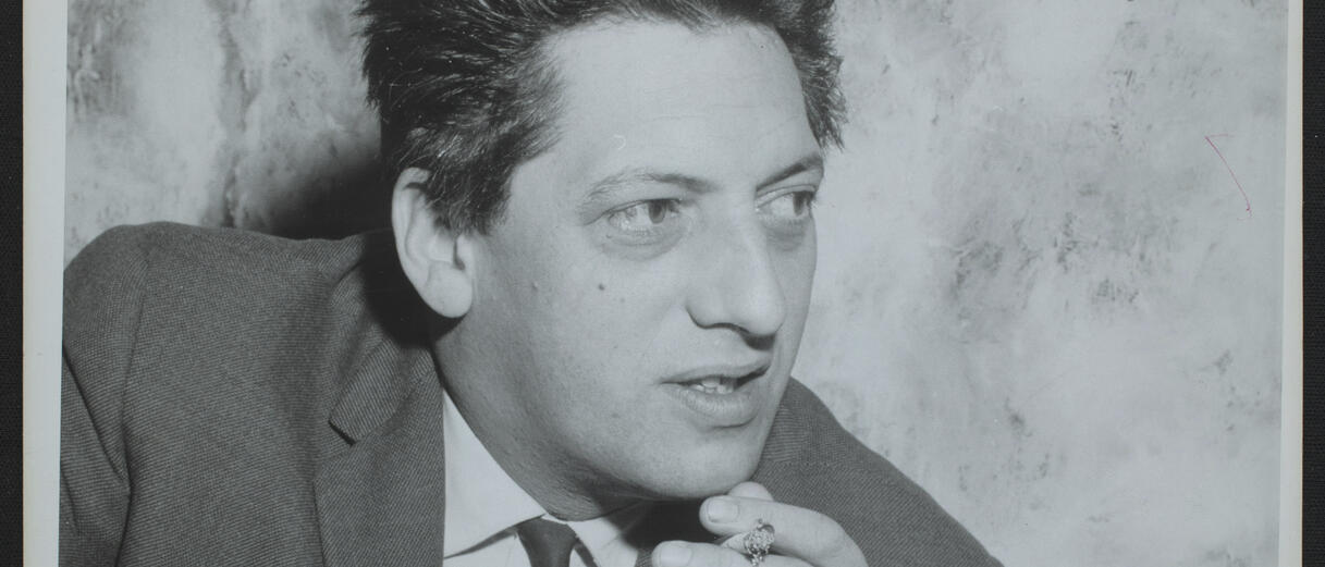 Jean Paul Riopelle tient une cigarette.