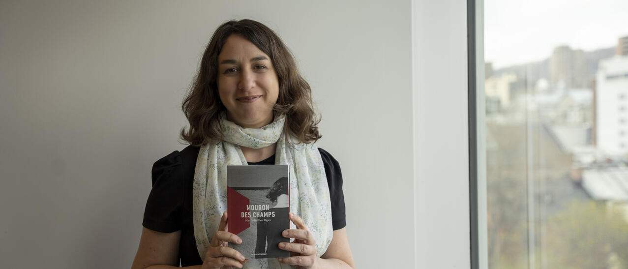 Esther Laforce, bibliothécaire de la Grande Bibliothèque et membre du balado « Signets au féminin », tenant le recueil « Mouron des champs » de Marie-Hélène Voyer