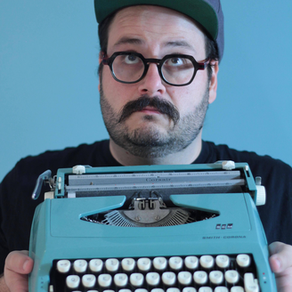 Un jeune homme tenant une machine à écrire.